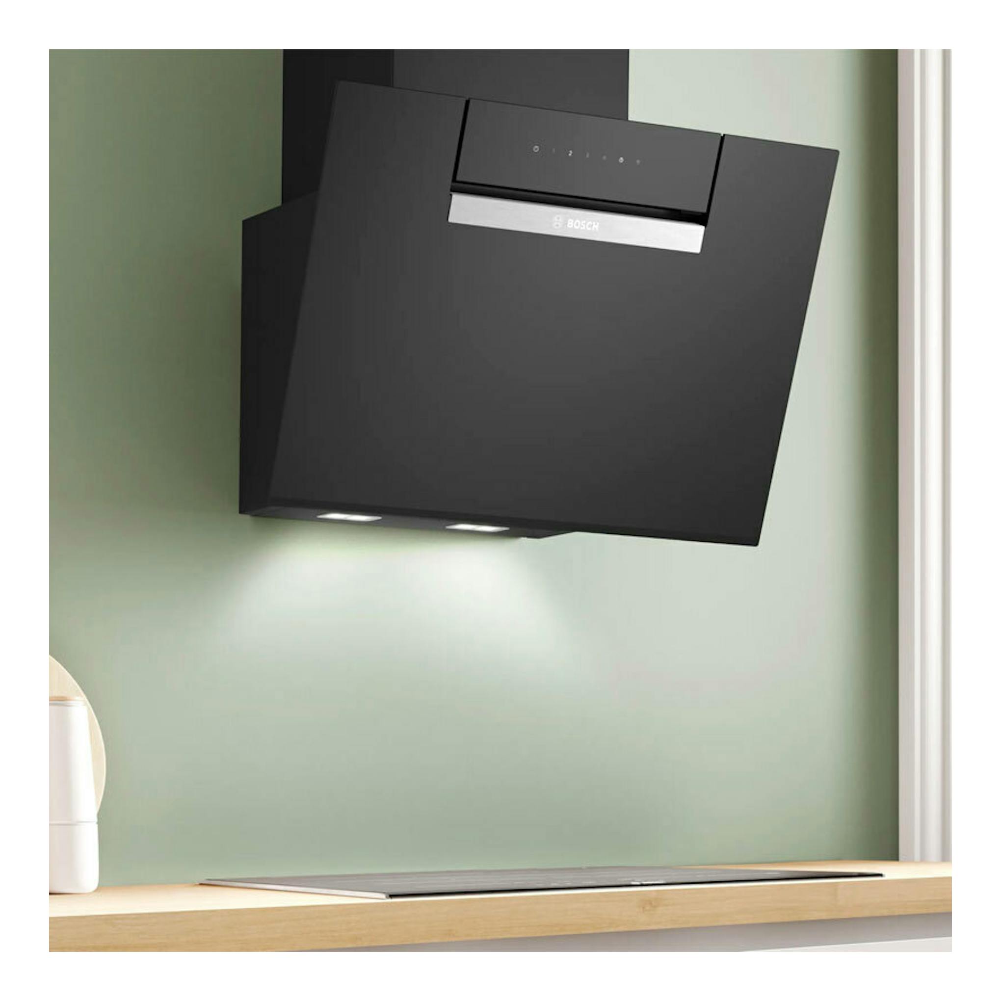 Campana decorativa Bosch DWK67FN60 de cristal negro, vista frontal inclinada, con luces inferiores encendidas.