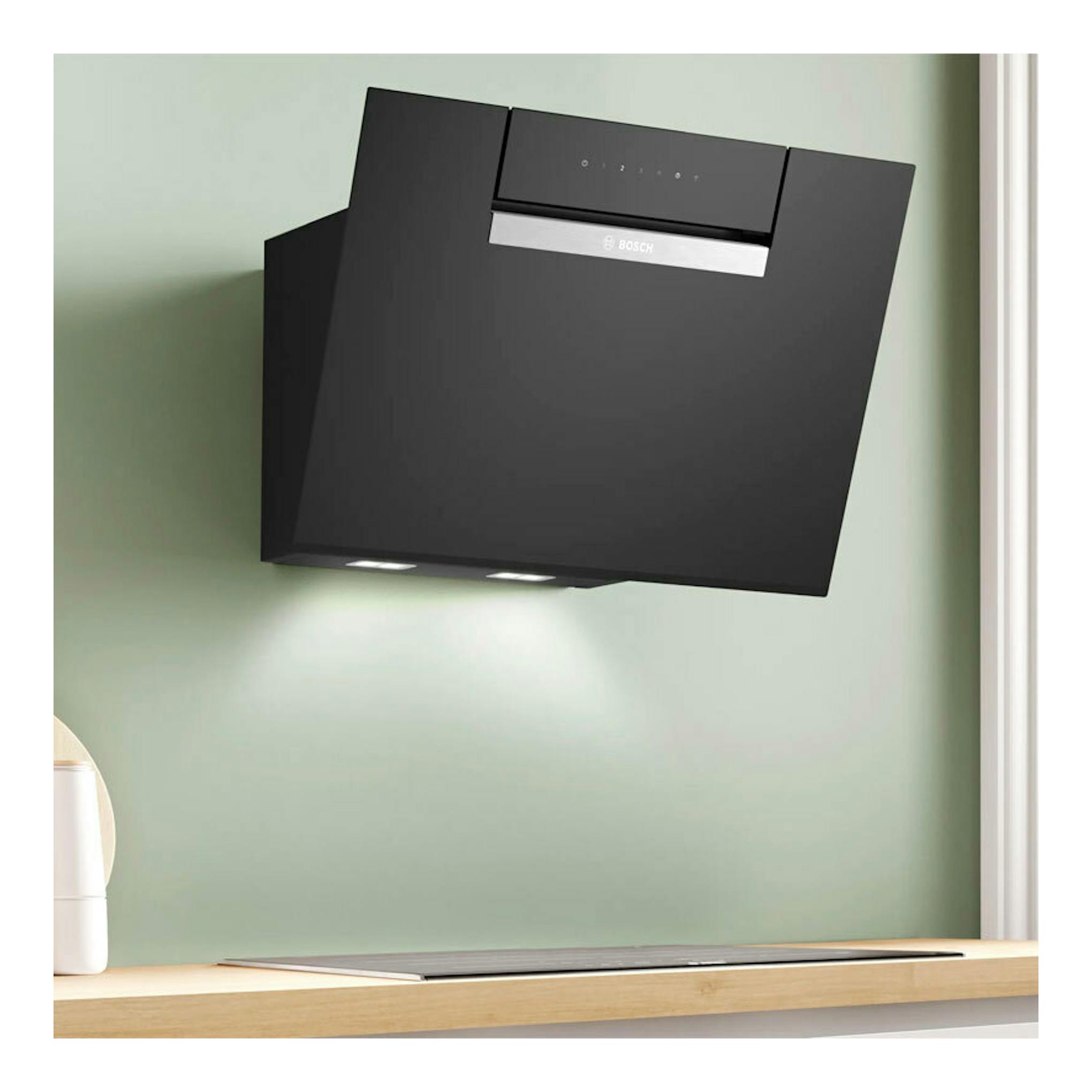 Campana decorativa Bosch DWK67FN60 de cristal negro, vista frontal inclinada, montada en pared.