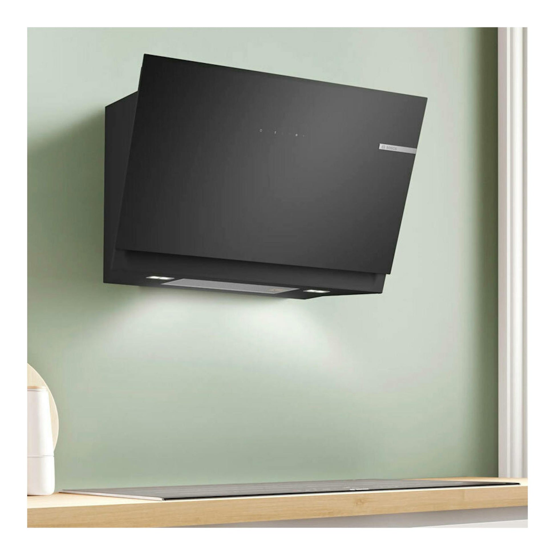 Campana decorativa Bosch DWK81AN60 de cristal negro, vista frontal inclinada sobre pared verde.