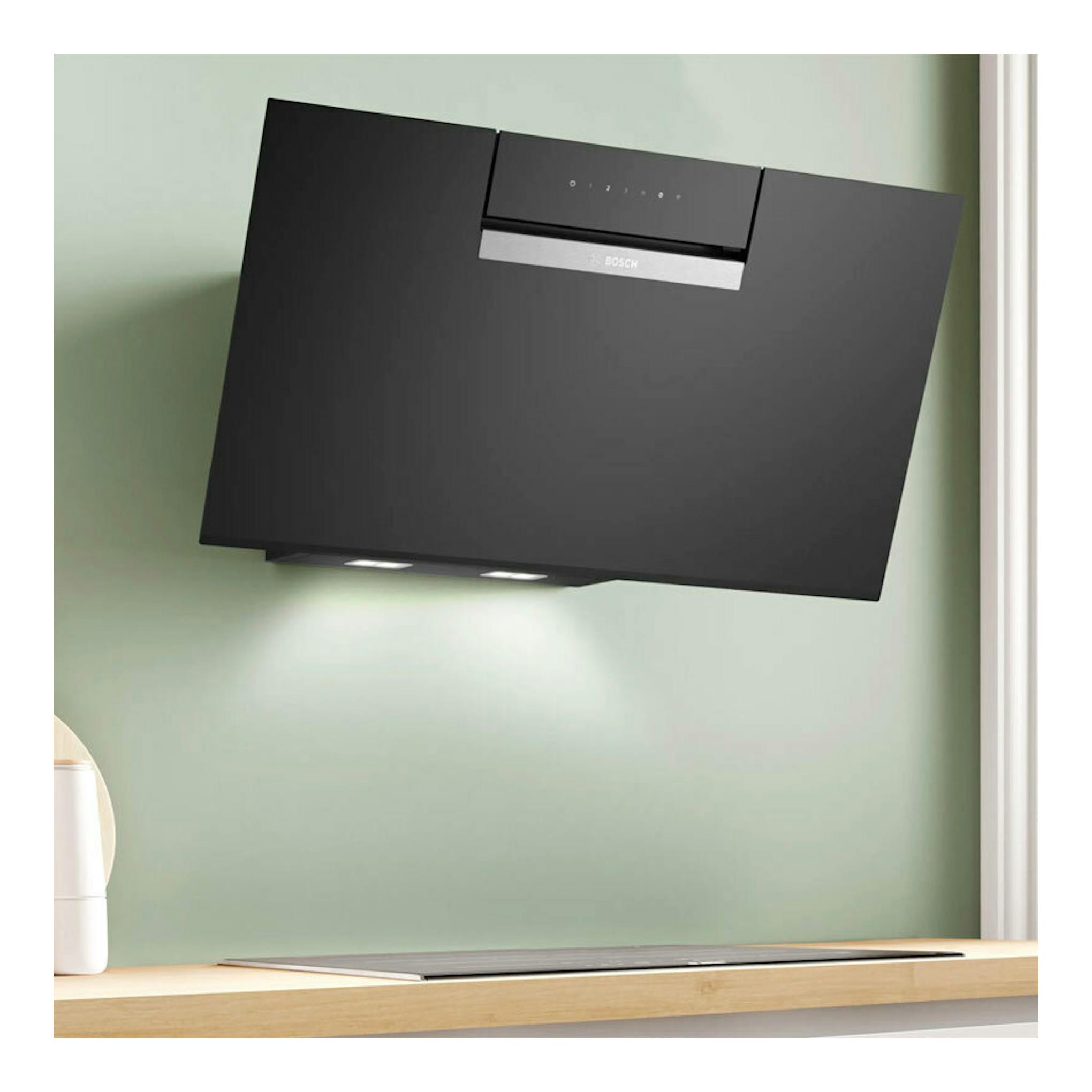 Campana decorativa Bosch DWK87FN60 de cristal negro, vista frontal inclinada, montada en pared.