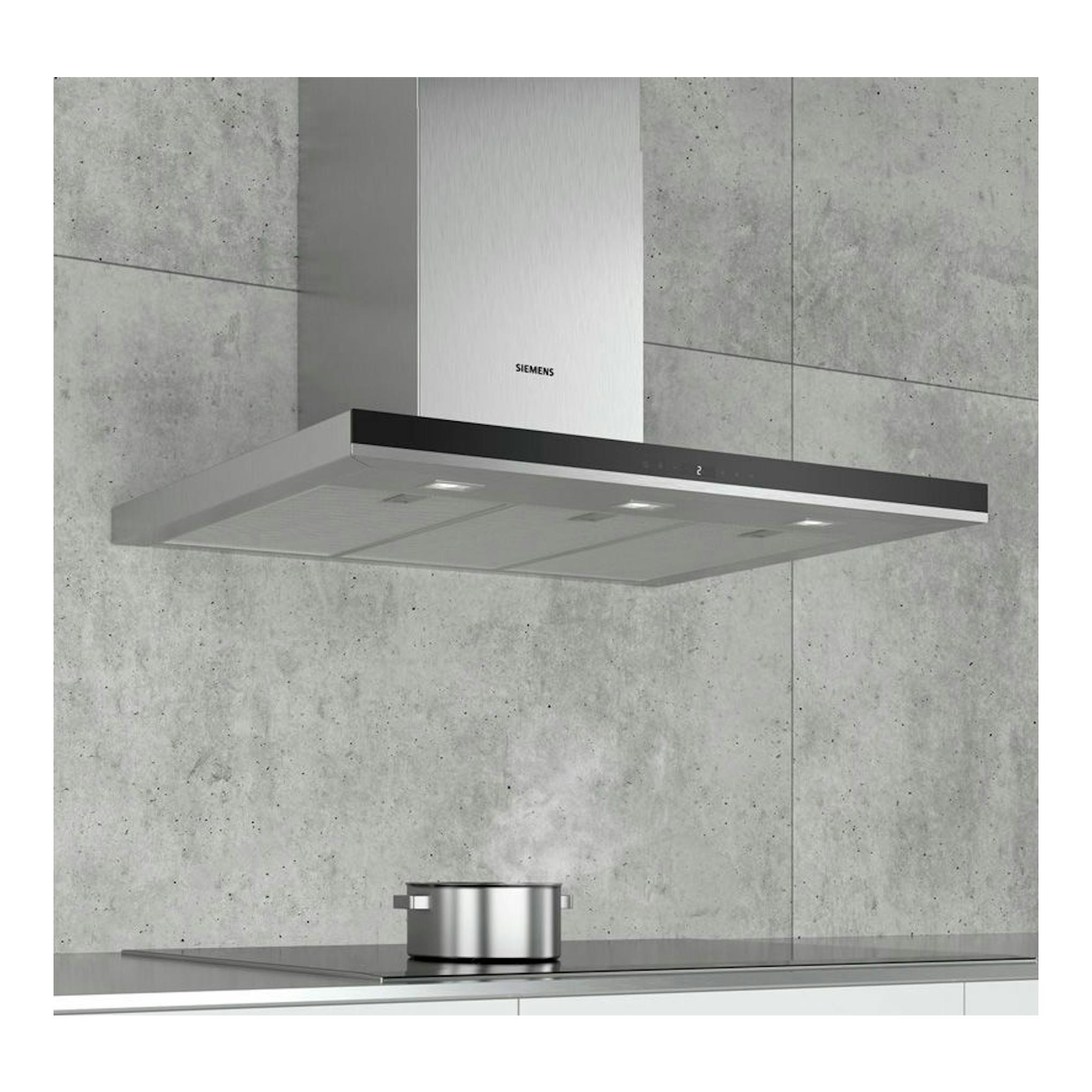 Campana decorativa de pared Siemens LC97BHP50 inox, vista frontal, sobre cocina con fondo de hormigón.