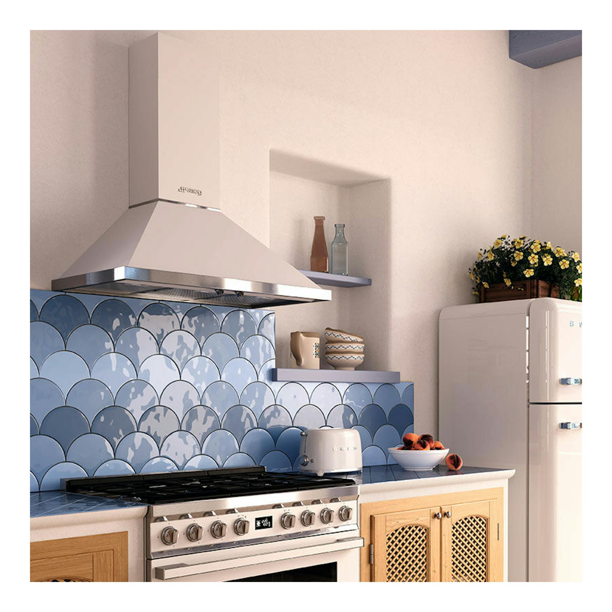Campana decorativa Smeg KPF9WH blanca, vista frontal sobre cocina con azulejos azules.