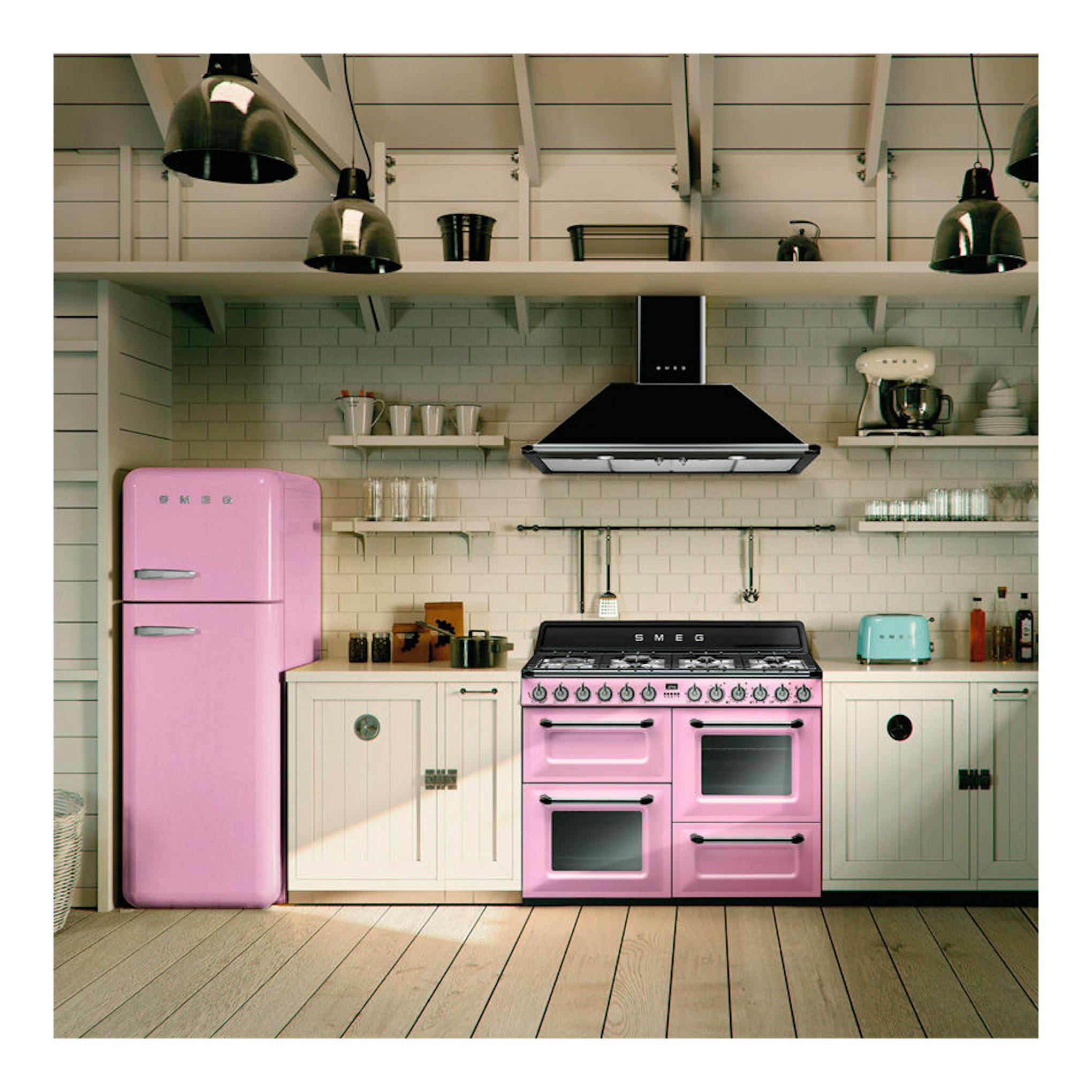 Campana decorativa Smeg KT110BLE negra, vista frontal, sobre cocina con muebles y electrodomésticos rosas.