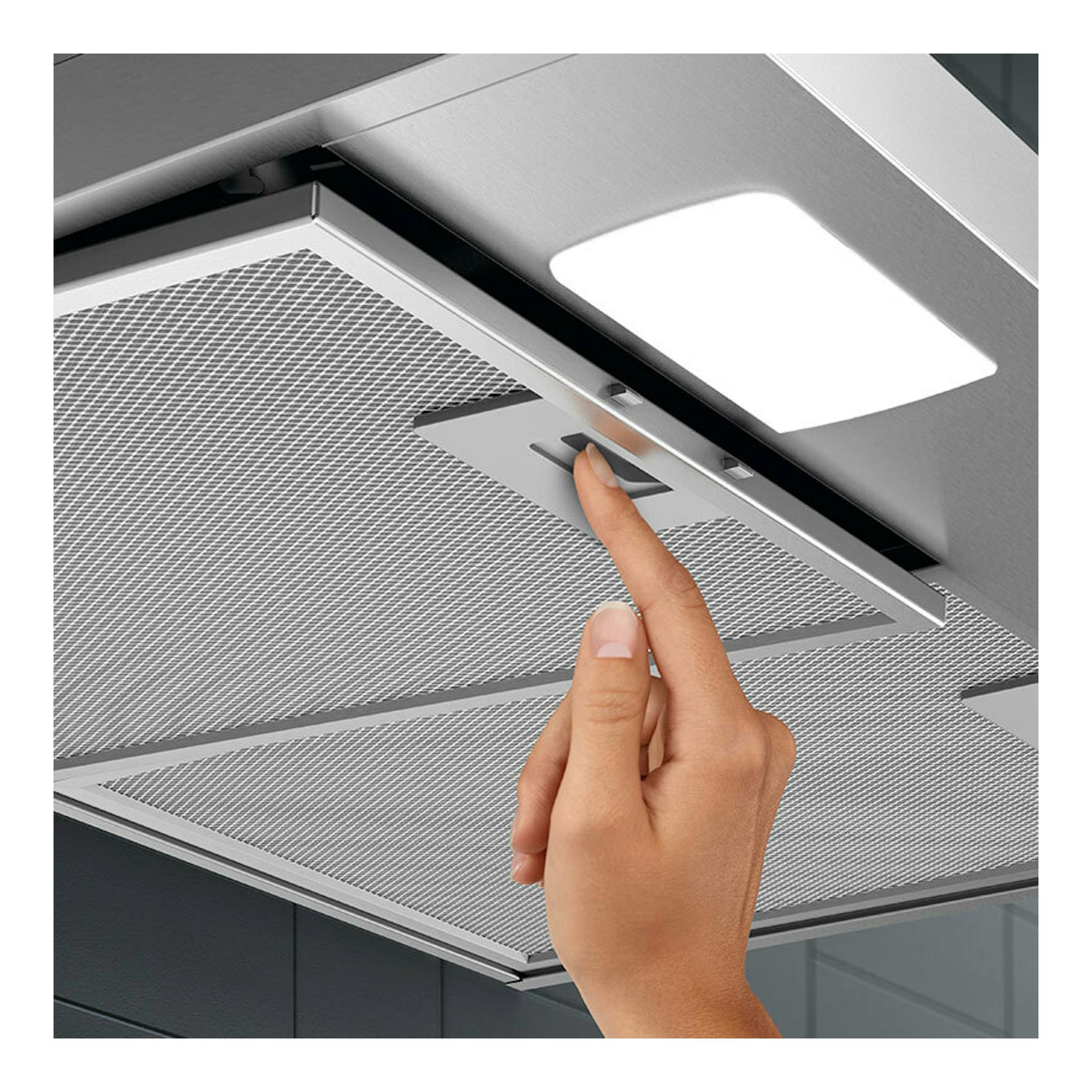 Campana extractora Electrolux LFC316X de inox, vista inferior, con una mano pulsando el control y luz encendida.