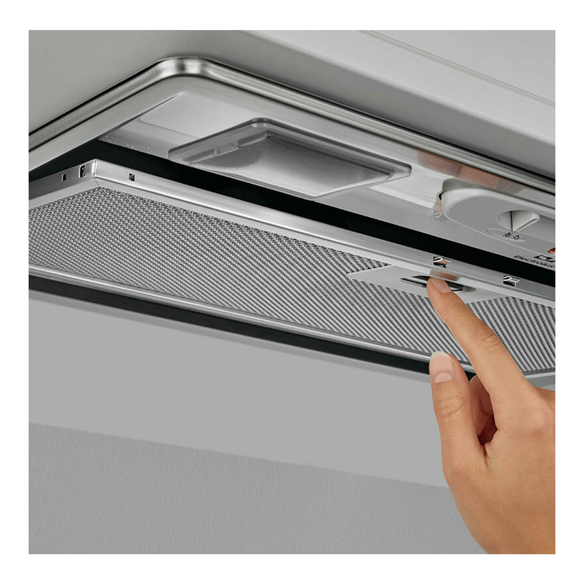 Campana extractora Electrolux LFG235S inox, vista inferior, con una mano pulsando un botón.