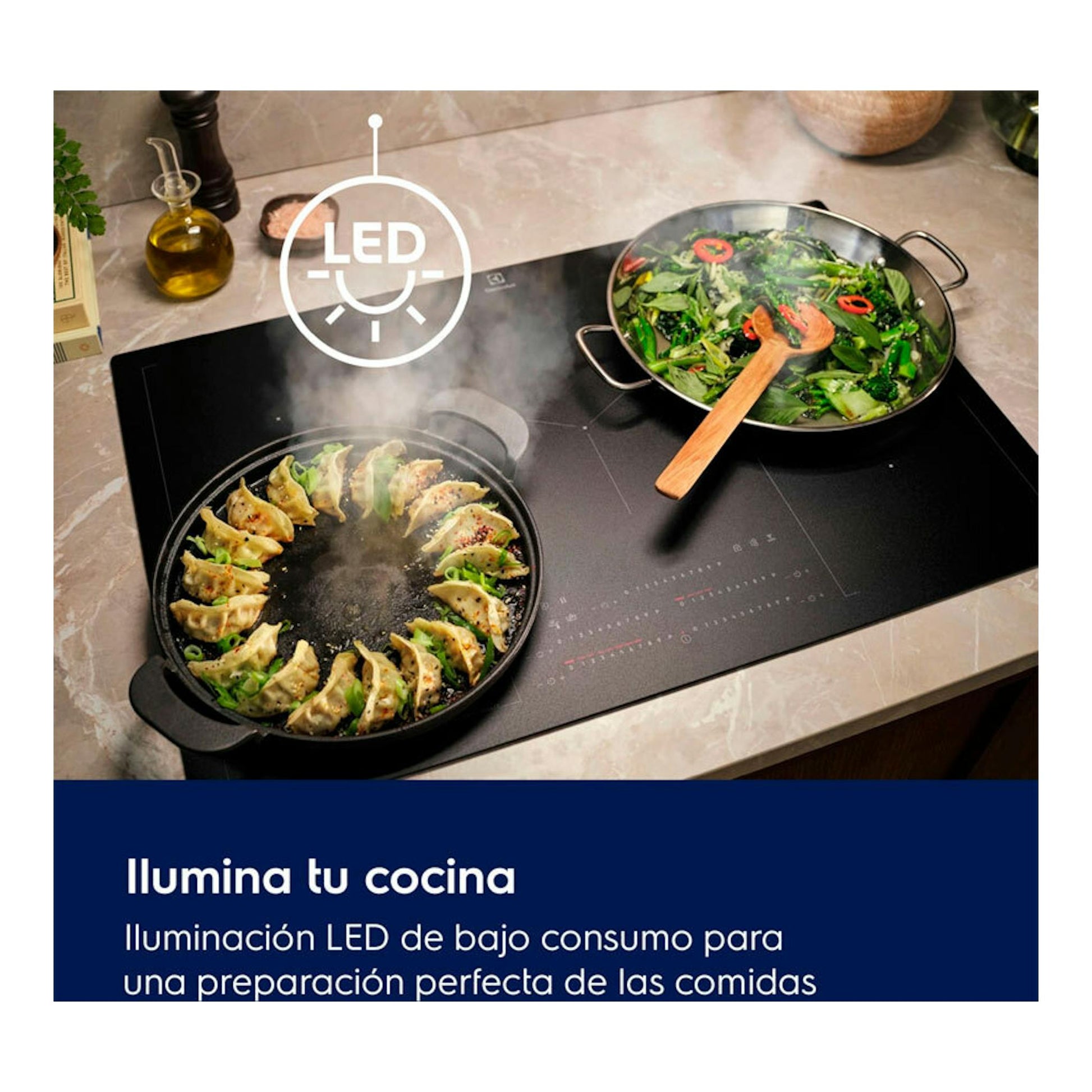 Placa de cocina negra, vista cenital, con dos sartenes y vapor; icono LED y texto promocional.