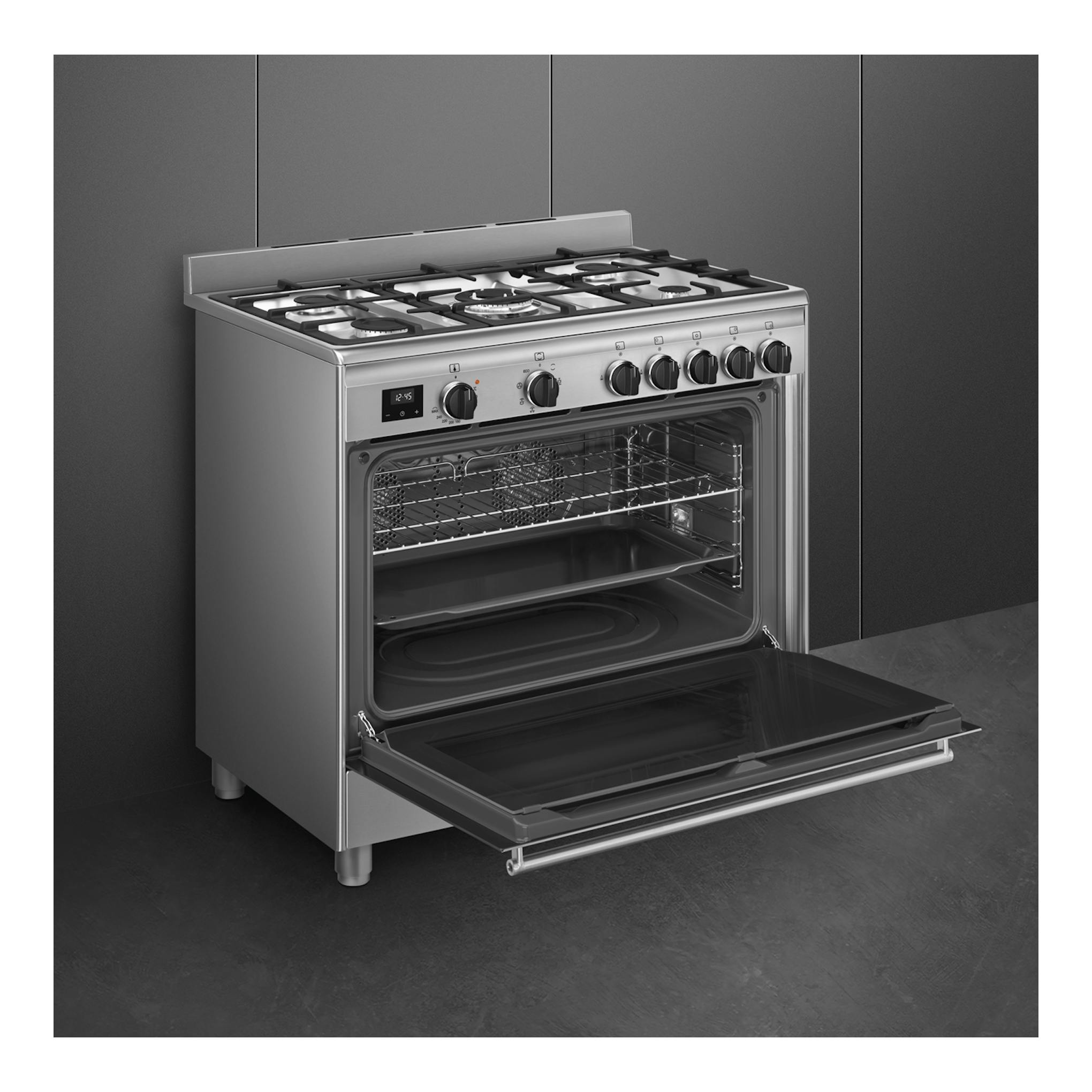 Cocina Smeg BG91X2 de acero inoxidable, vista frontal en ángulo, con horno abierto y 5 fuegos de gas.
