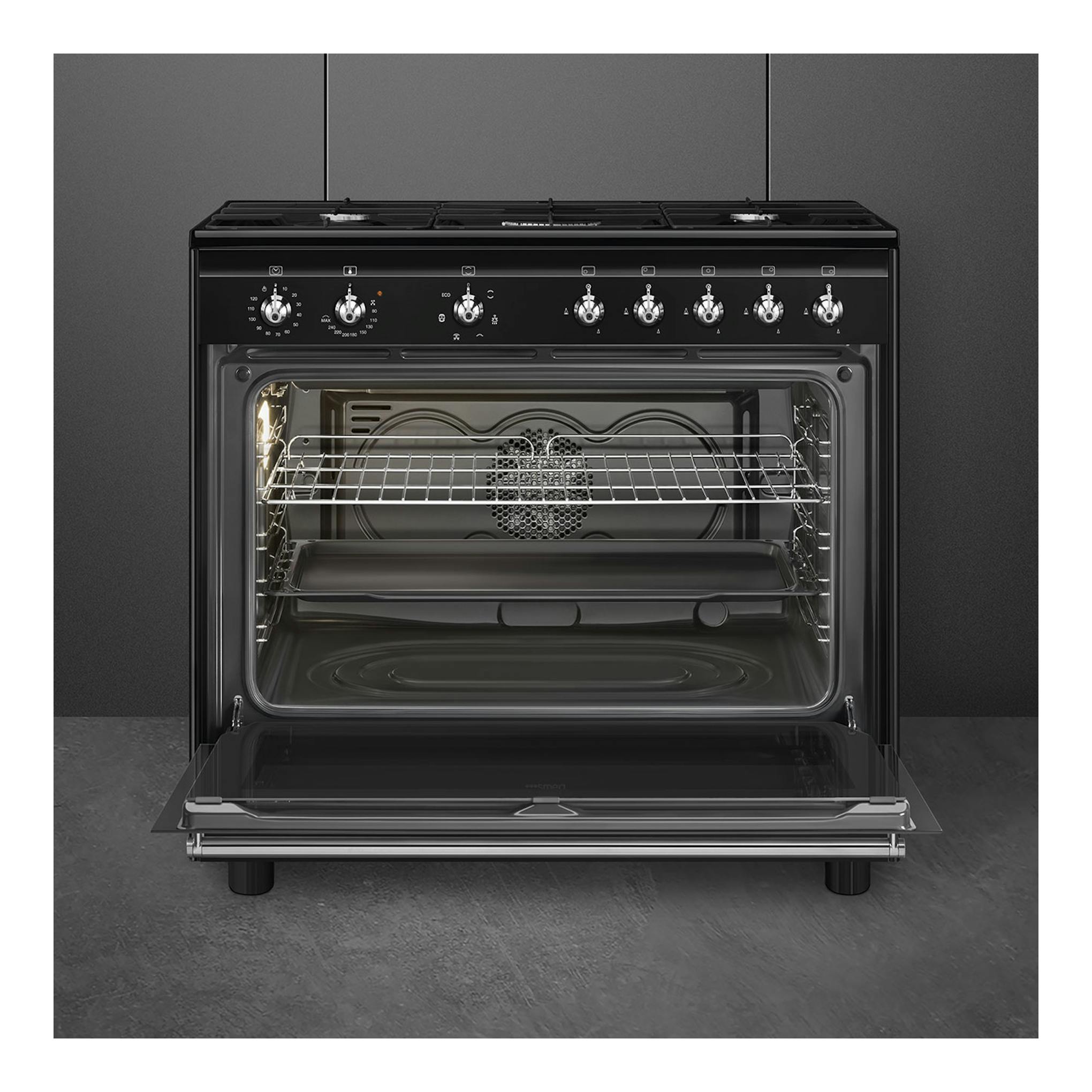 Cocina Smeg CX91GMBL negra, vista frontal, con horno abierto y cinco mandos en el panel superior.