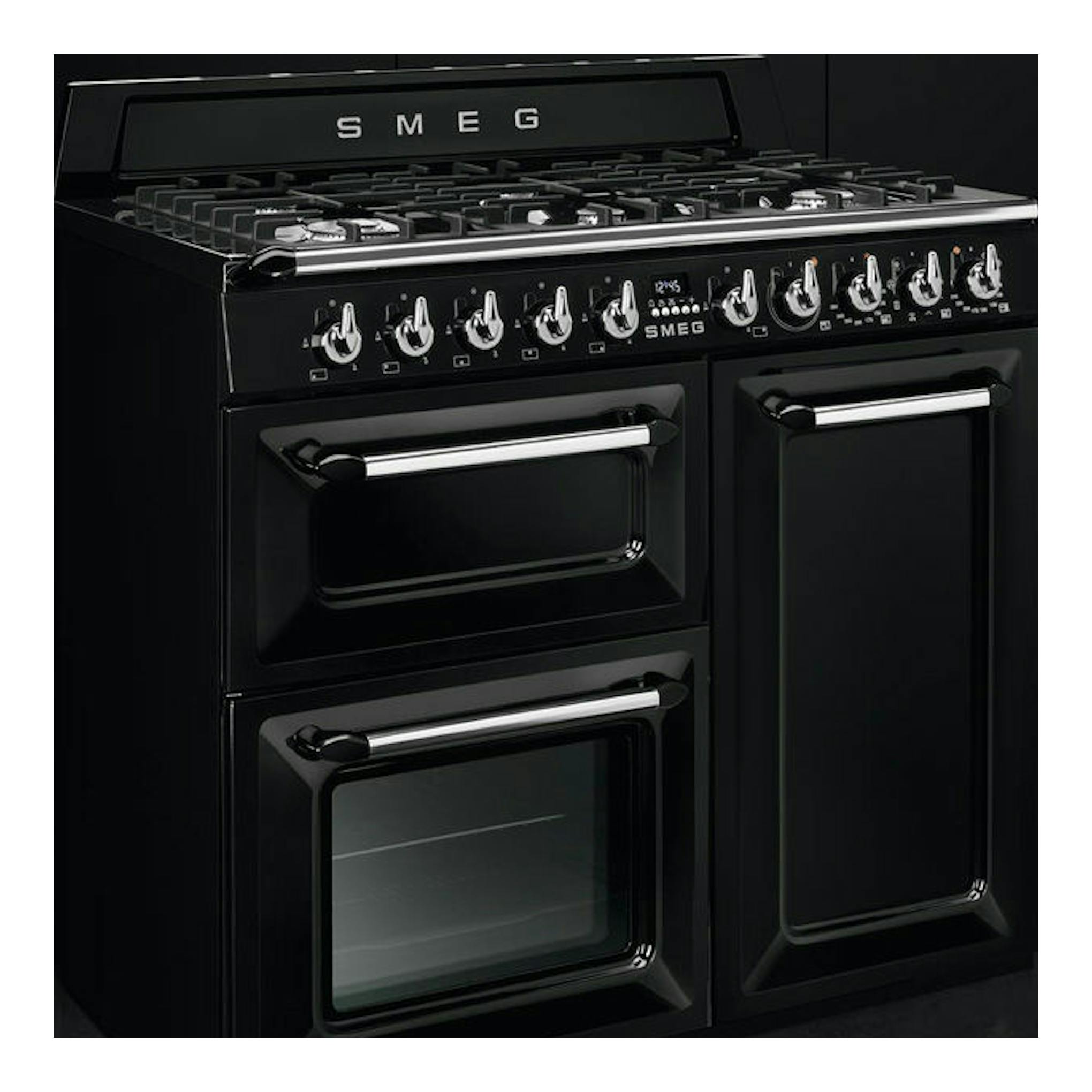 Cocina Smeg TR103BL negra, vista frontal en ángulo, con cinco fogones y tres puertas de horno.