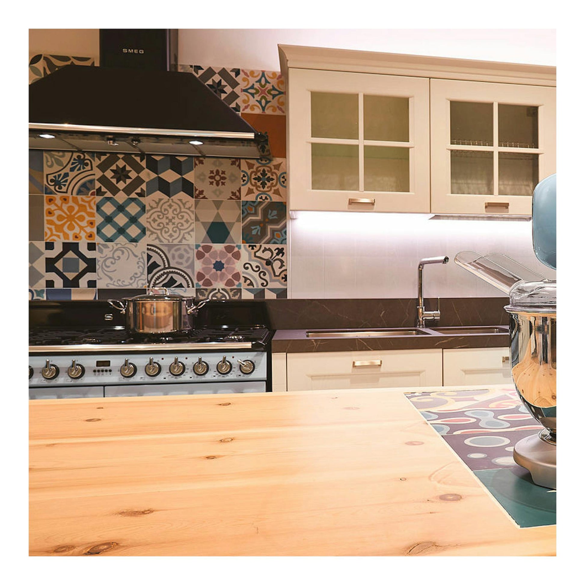 Cocina Smeg TR4110AZ negra y plateada, vista frontal, instalada junto a azulejos decorativos.