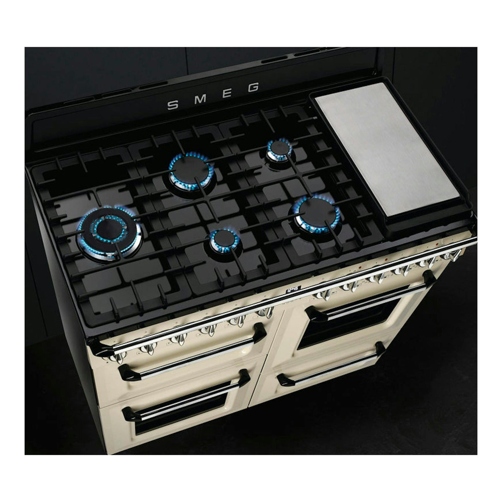 Cocina Smeg TR4110P1 negra y crema, vista superior en ángulo, con 5 fuegos y plancha lateral.