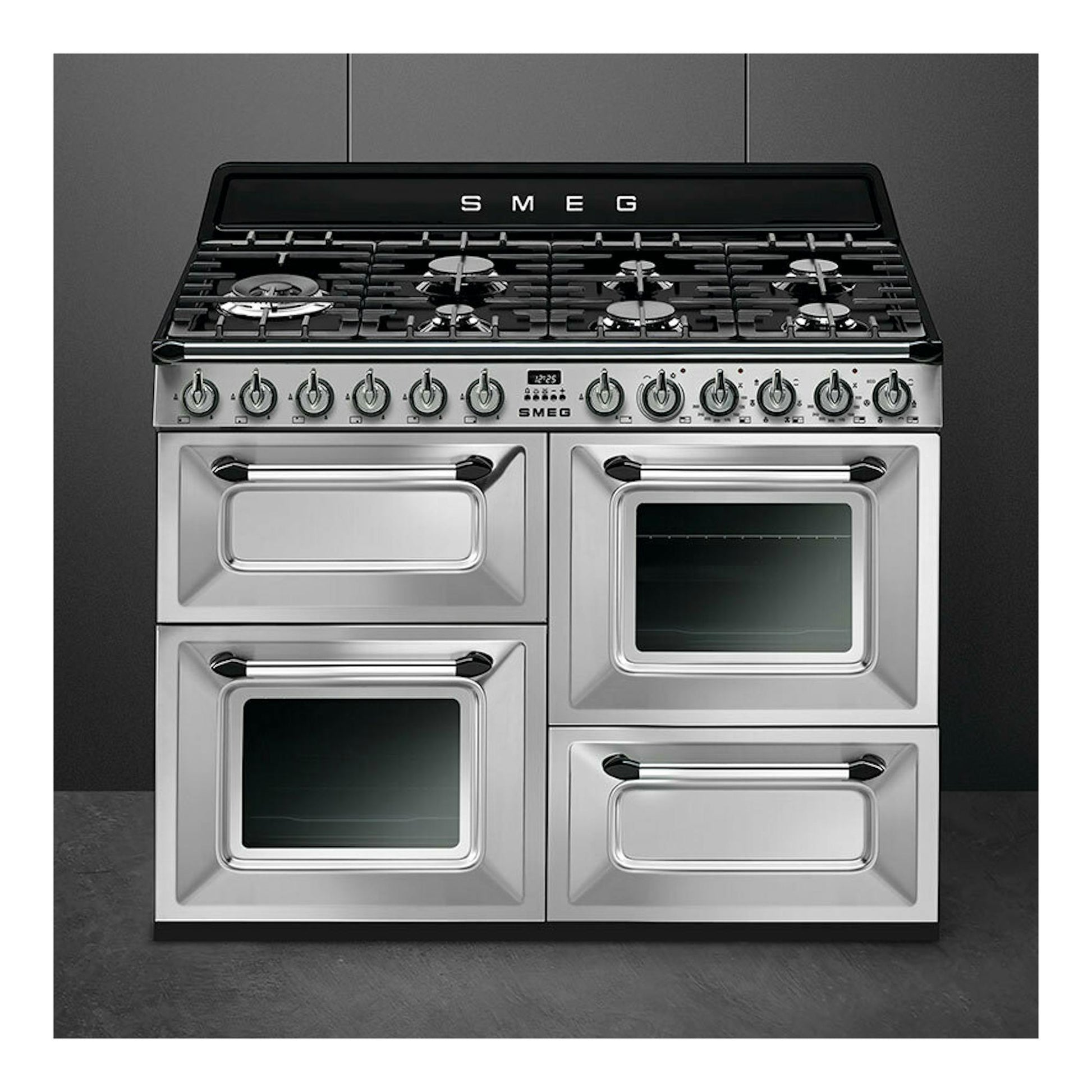 Cocina Smeg TR4110X-1 de 110 cm, acero inoxidable, vista frontal, con encimera de gas negra y cuatro puertas.