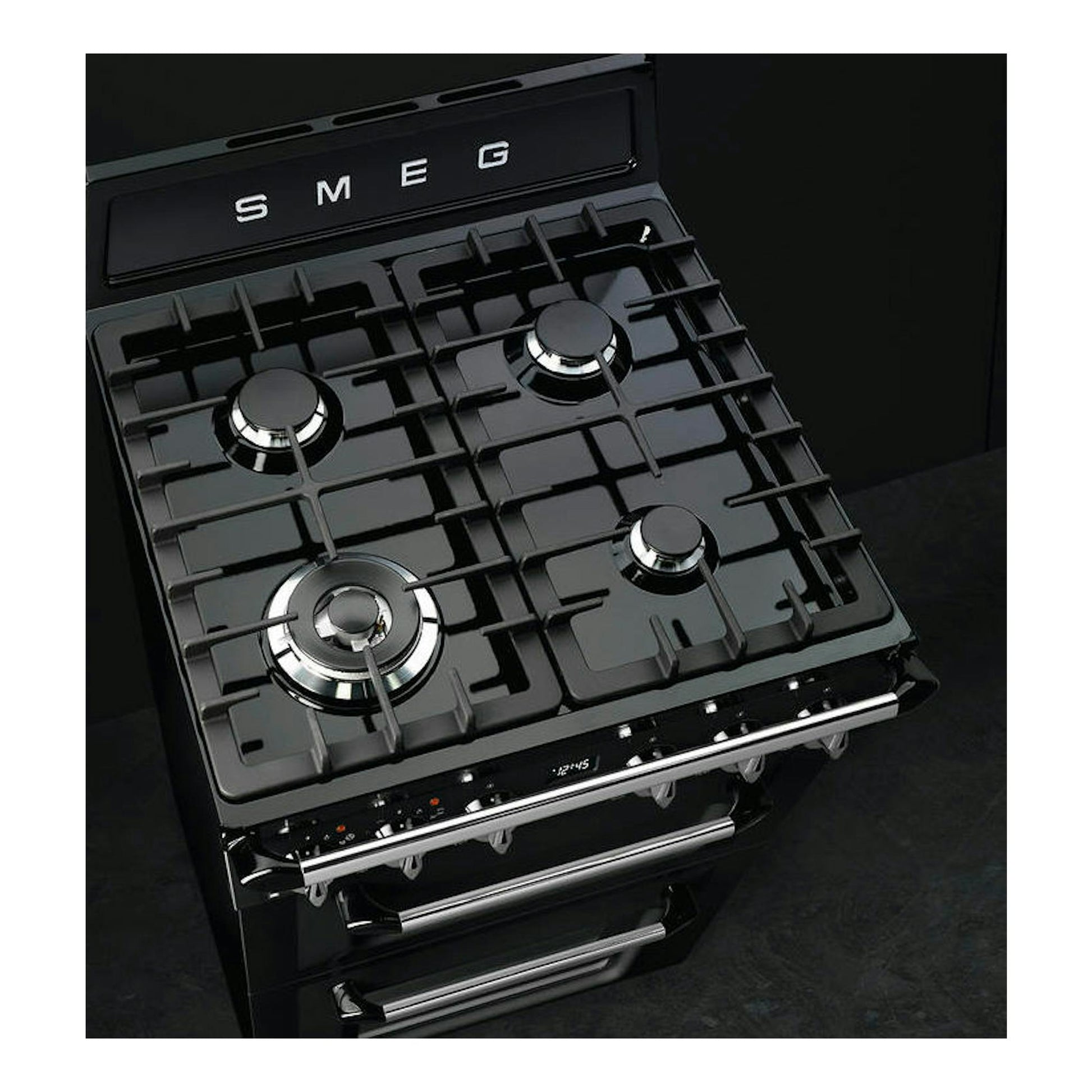Cocina Smeg TR62BL negra de 60 cm, vista en ángulo superior con cuatro quemadores y horno.