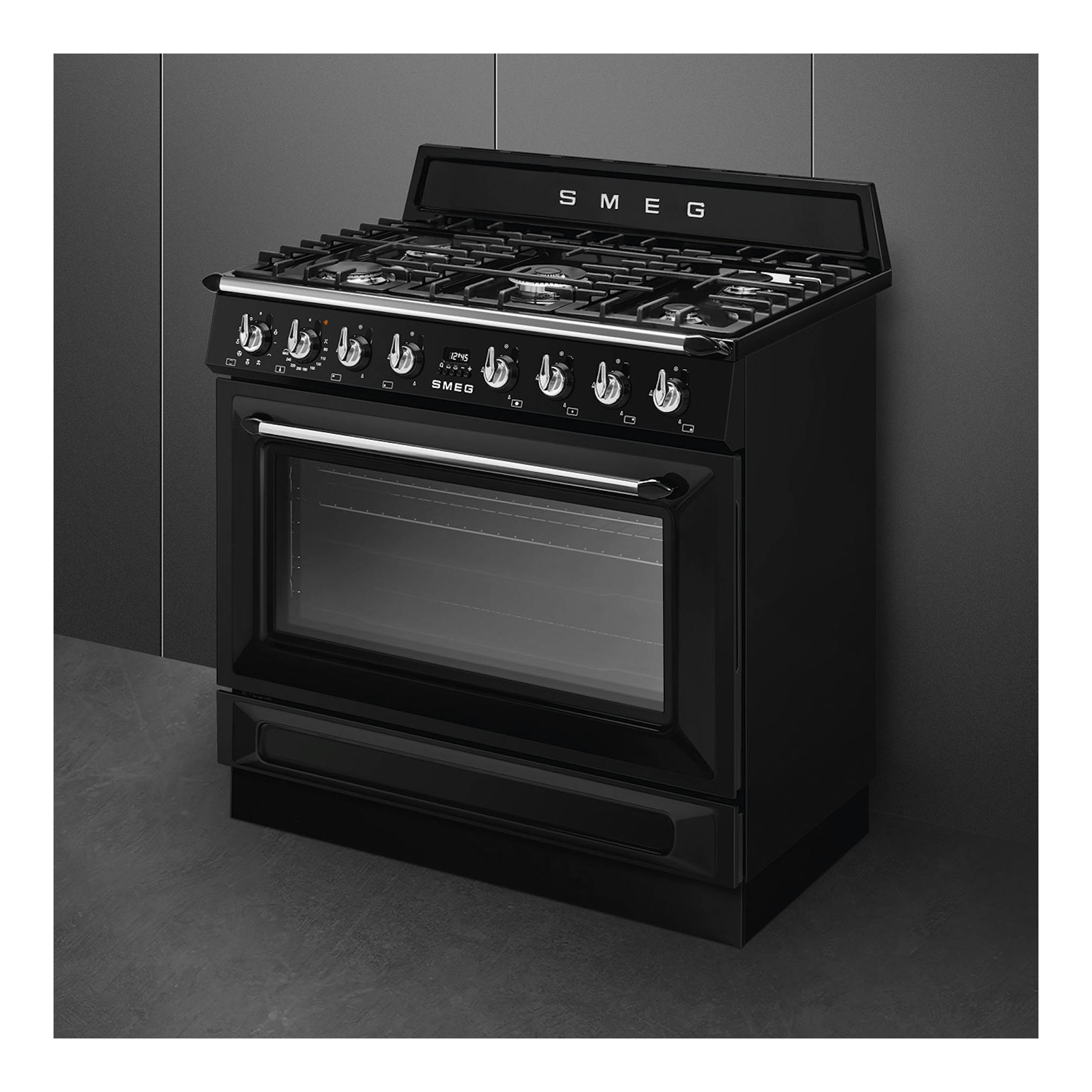 Cocina de gas SMEG TR90GMBL negra, vista frontal tres cuartos, con horno y 5 fuegos.