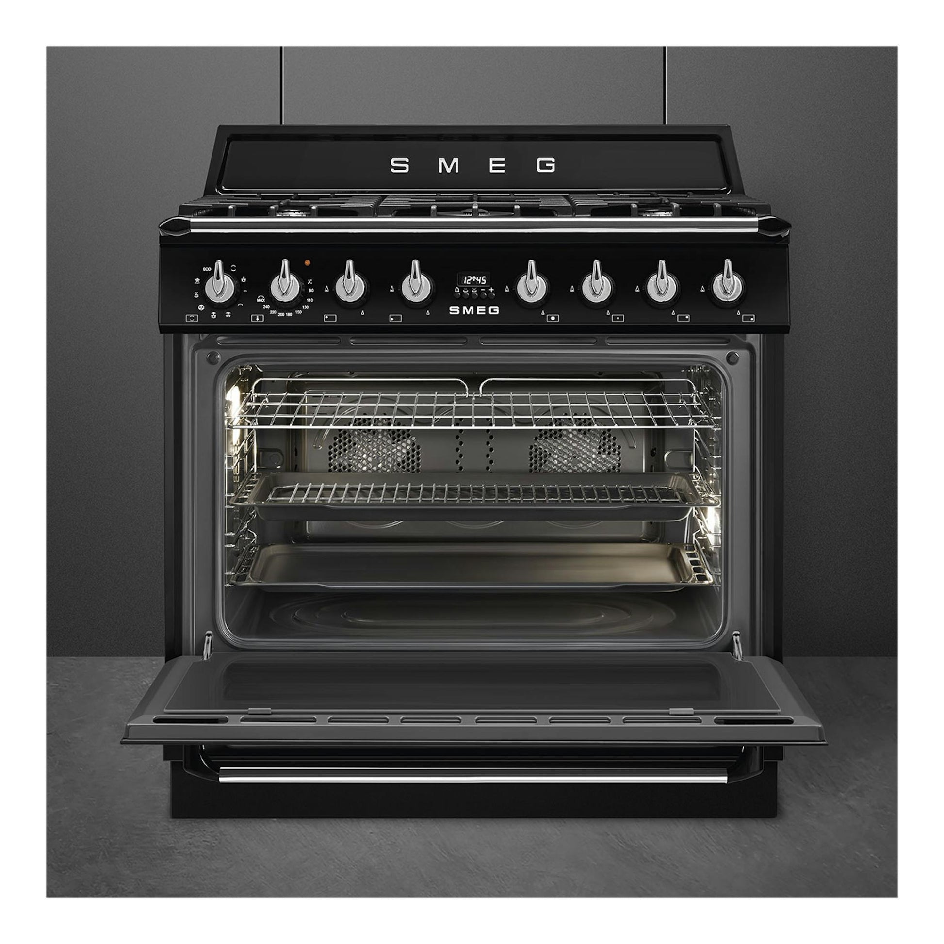 Cocina Smeg TR90GMBL negra, vista frontal, con horno abierto y cinco mandos en el panel.