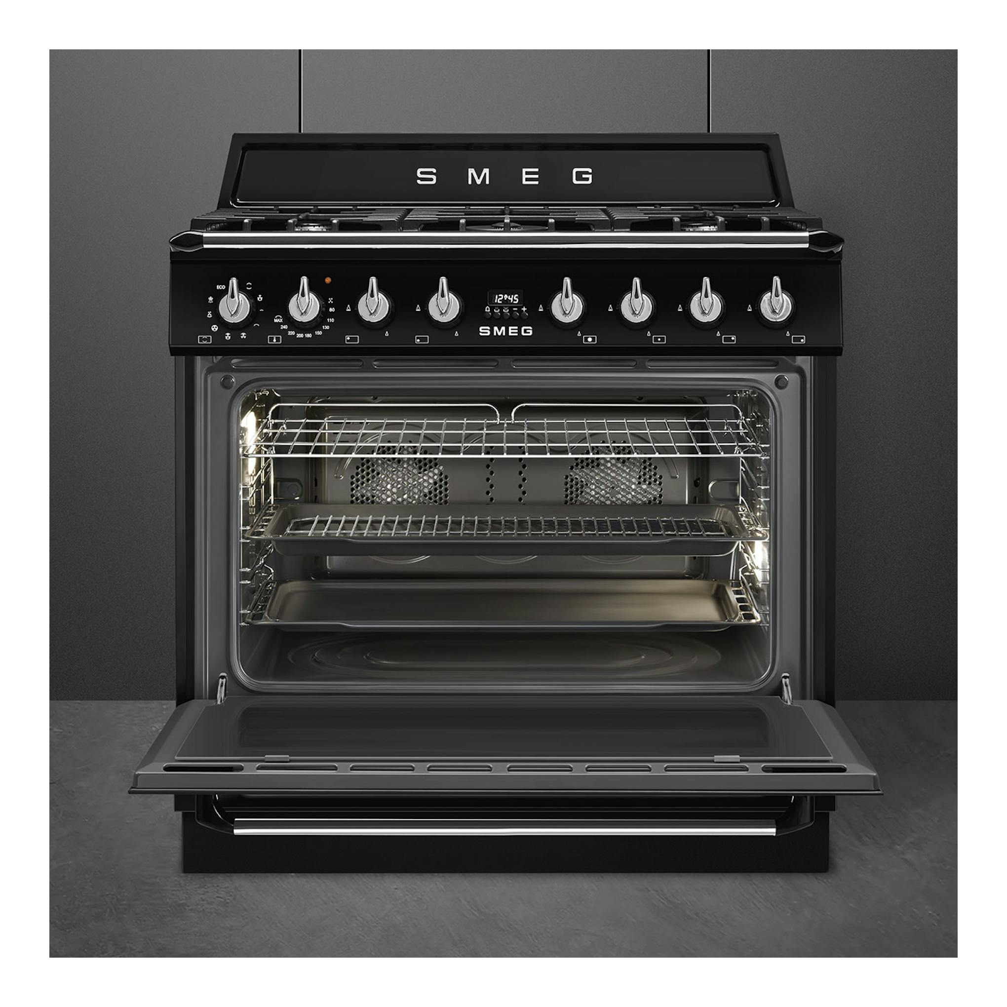 Cocina Smeg TR90GMBL negra, vista frontal, con horno abierto y cinco mandos en el panel.