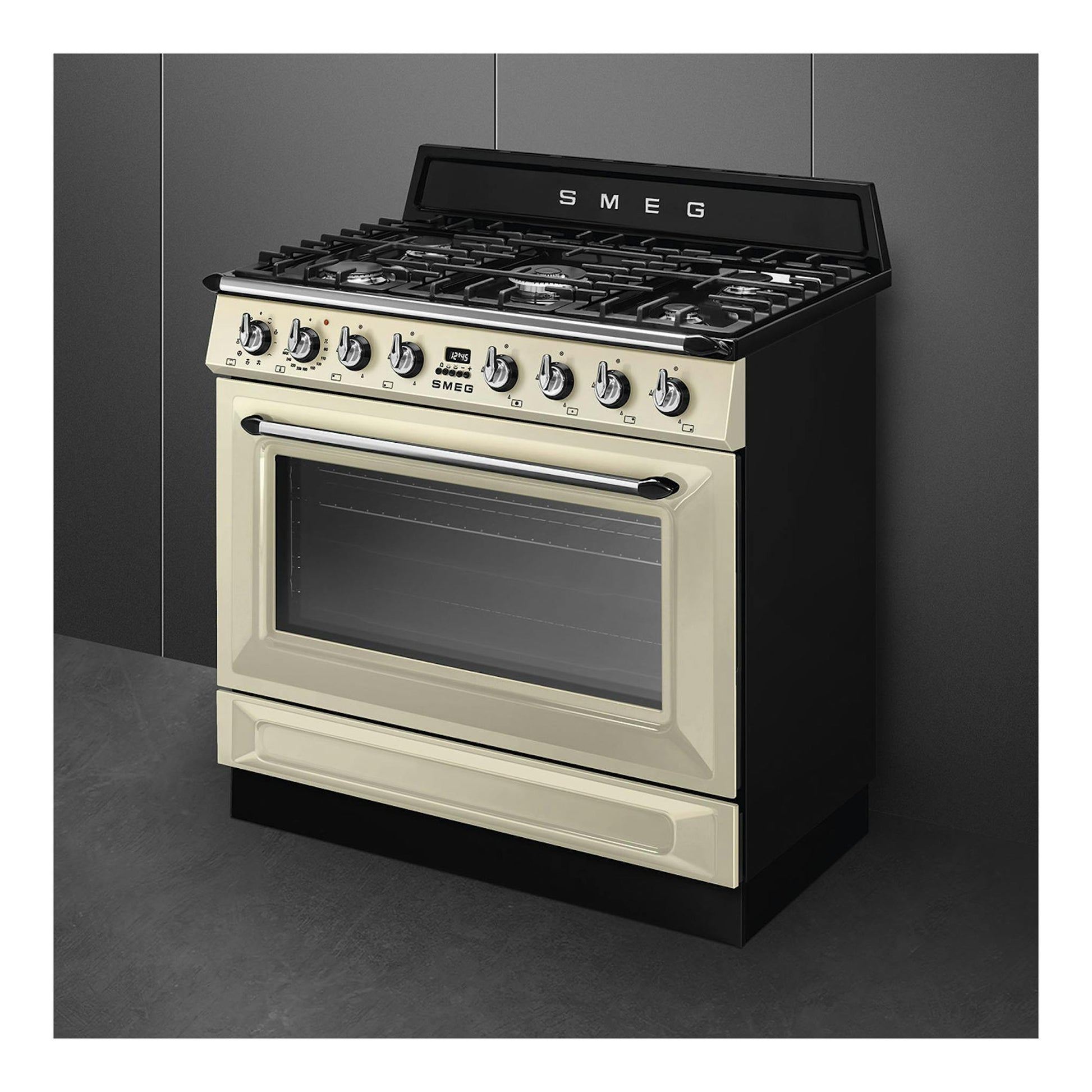 Cocina Smeg TR90GMP de gas, color crema y negro, vista frontal en ángulo, con horno y mandos.