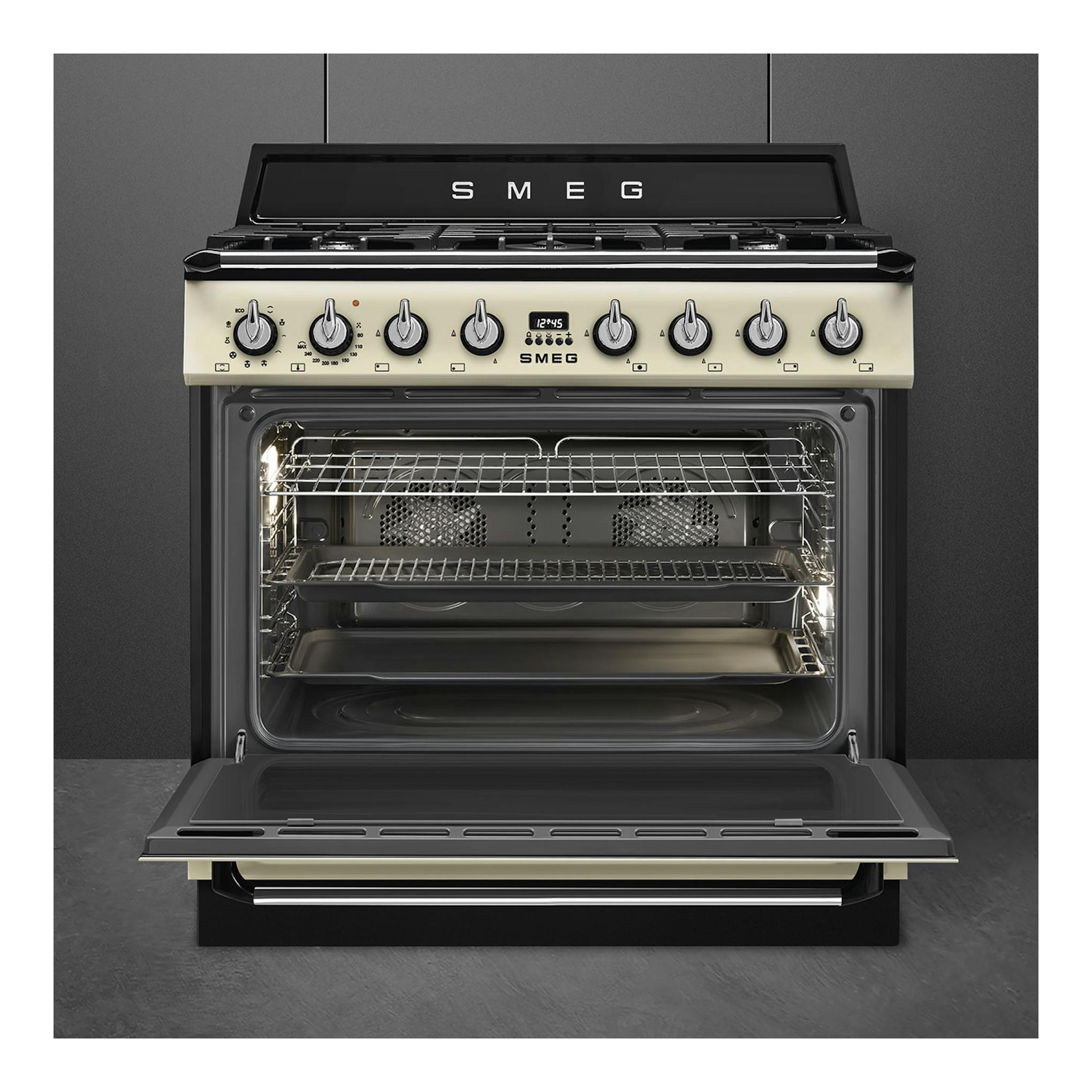 Cocina Smeg TR90GMP de gas, vista frontal, color crema y negro, con horno abierto.