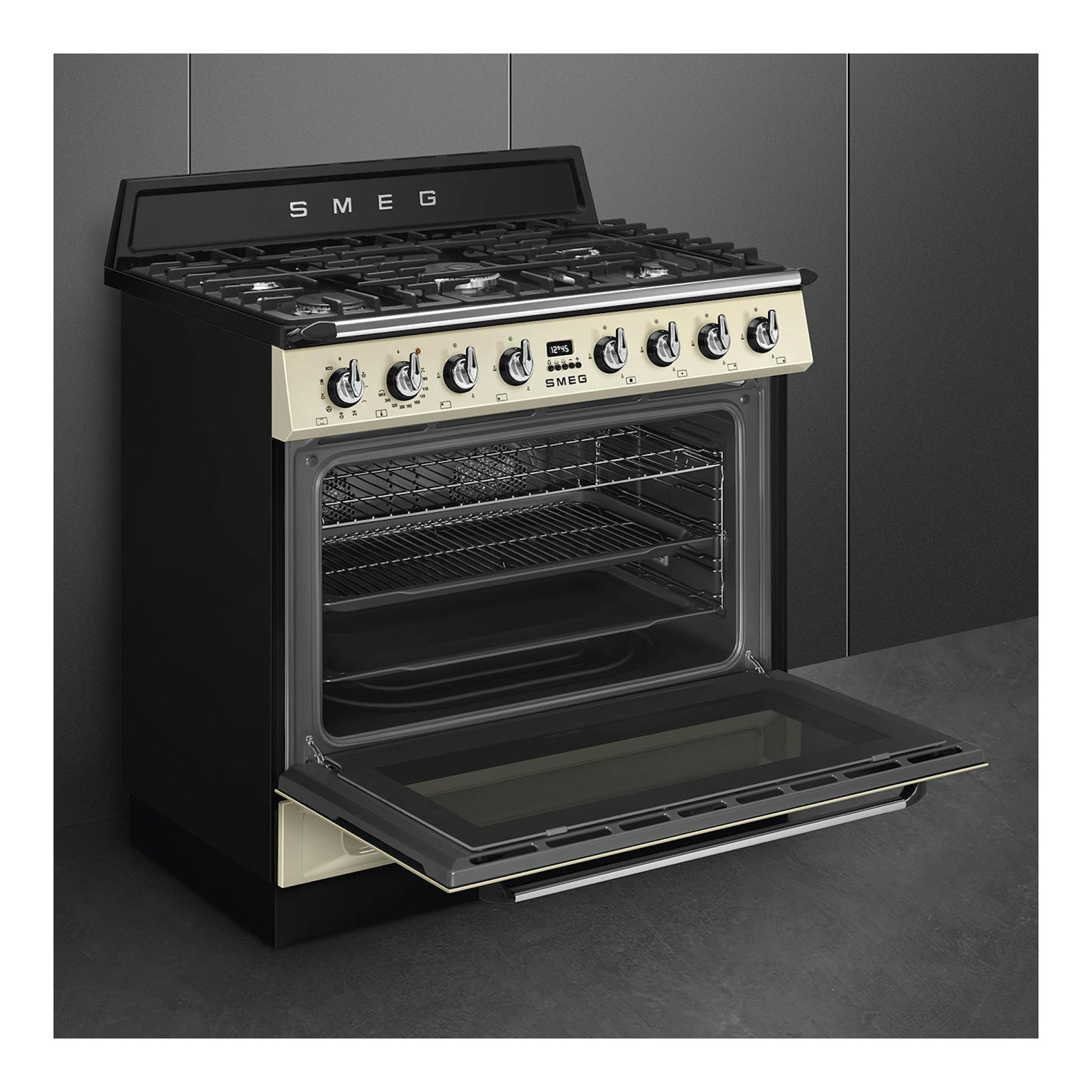Cocina Smeg TR90GMP negra y crema, vista frontal en ángulo, con horno abierto y 6 fuegos.