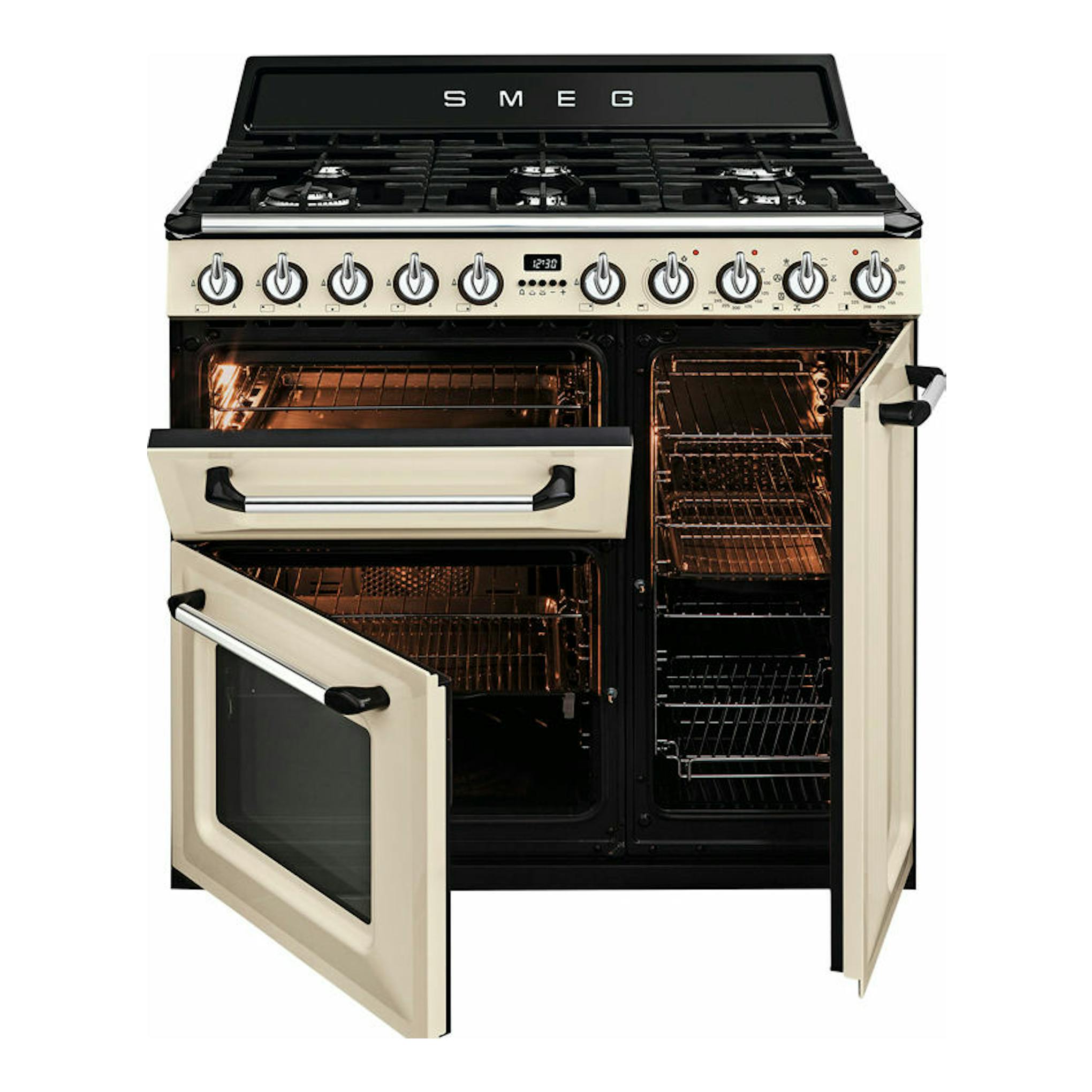Cocina Smeg TR93P beige y negra, vista frontal, con tres hornos y fuegos superiores, puertas abiertas.