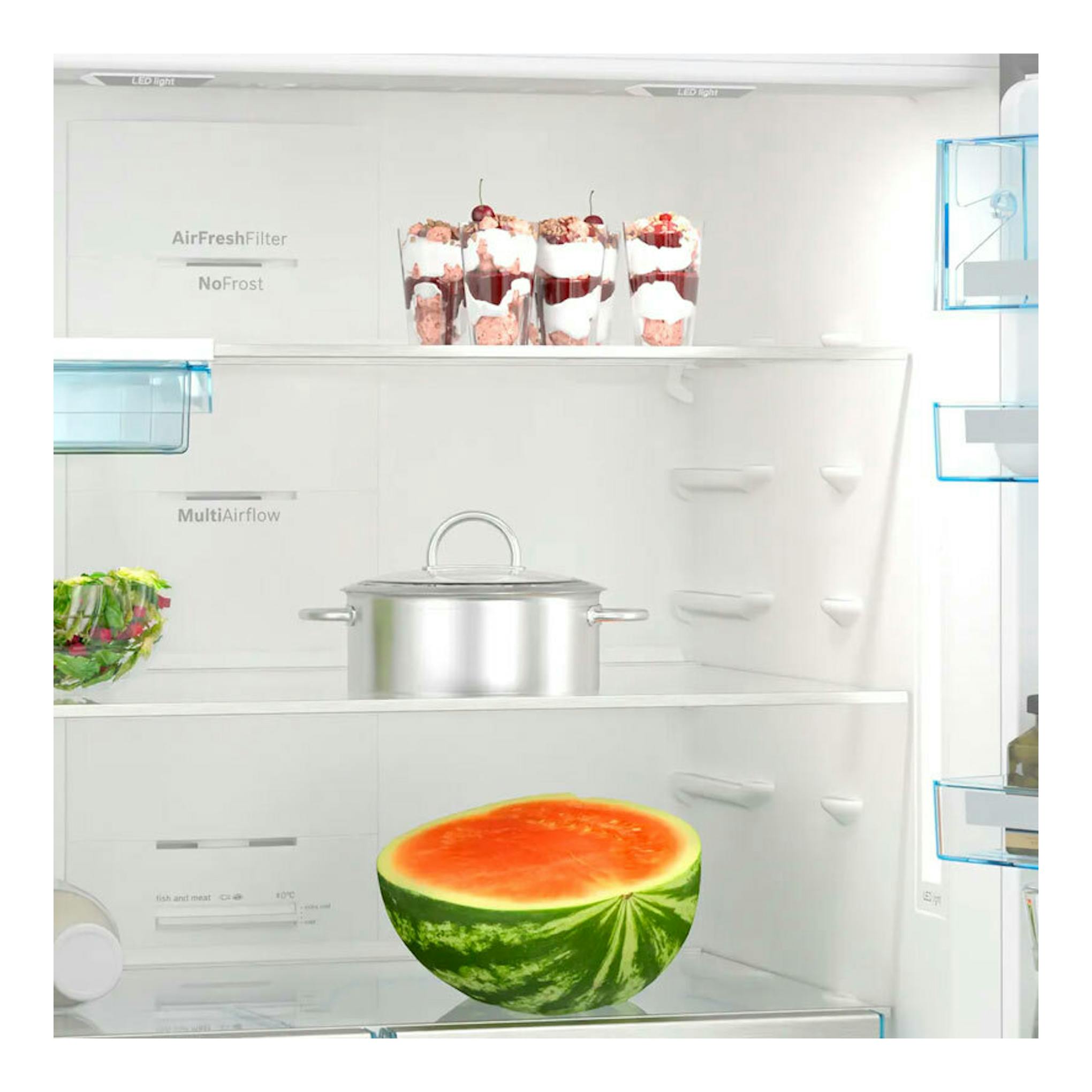 Interior de combi Bosch KGN86AIDR, vista frontal, interior blanco con estantes y alimentos.