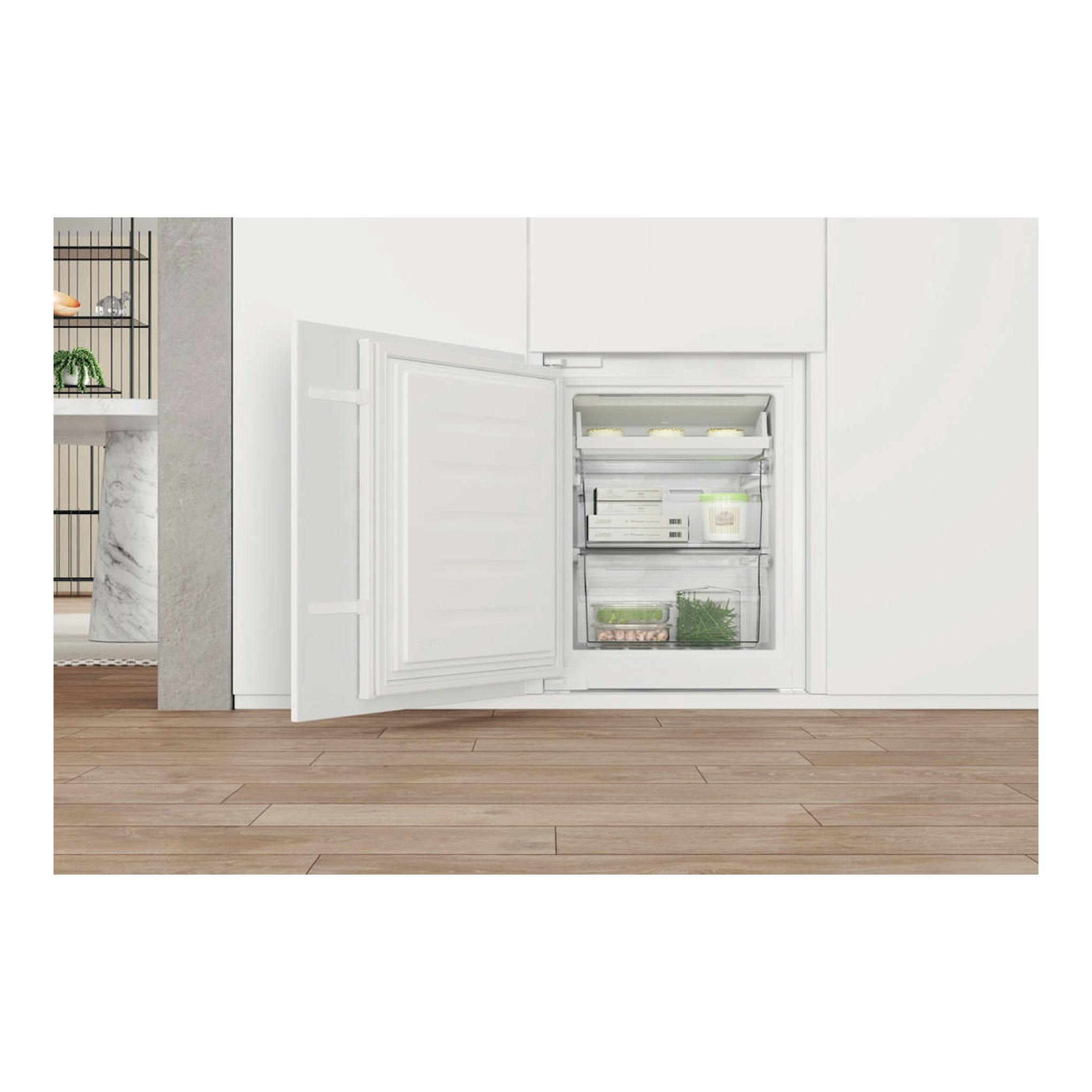Frigorífico combi Whirlpool WHC18 T311 blanco, integrable, vista frontal con la puerta abierta y compartimentos visibles.