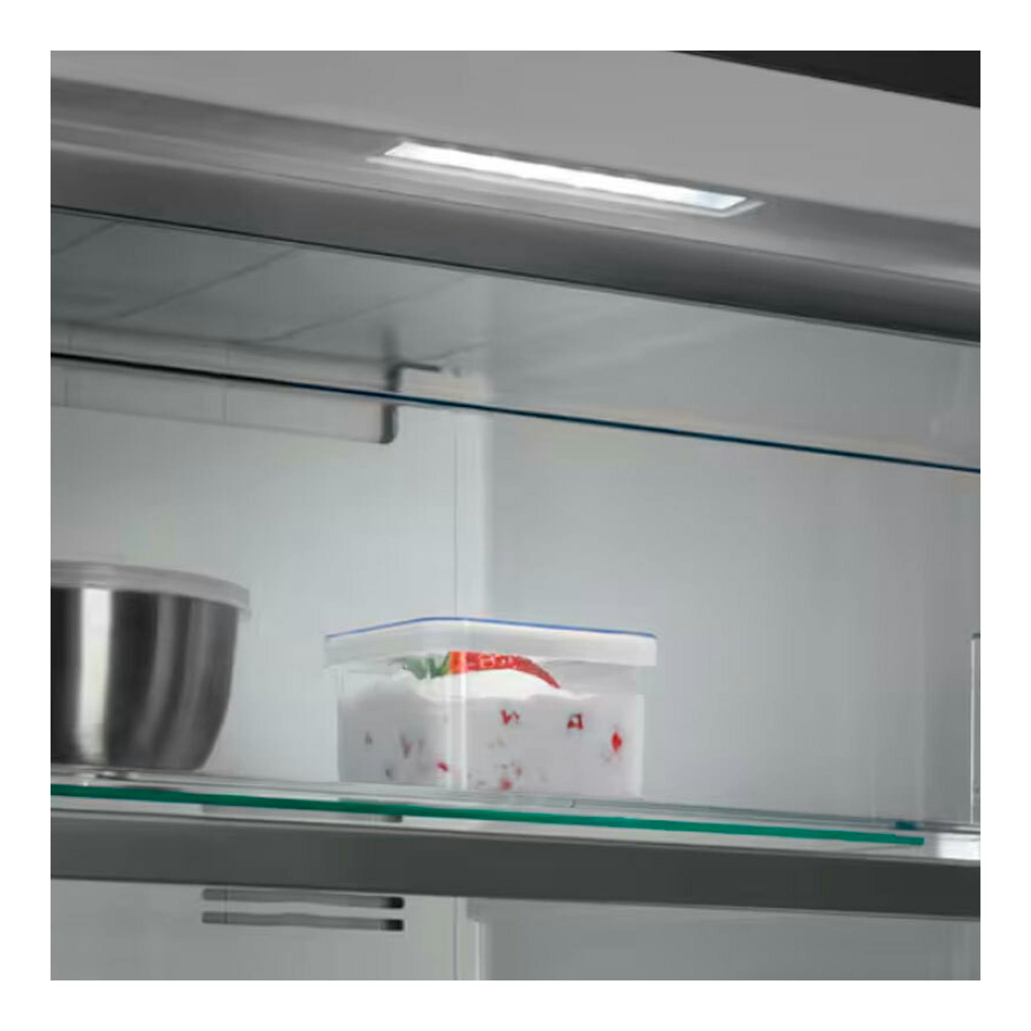 Interior de congelador blanco AEG OAG7M281EW, con estante de vidrio, bol metálico y recipiente plástico.