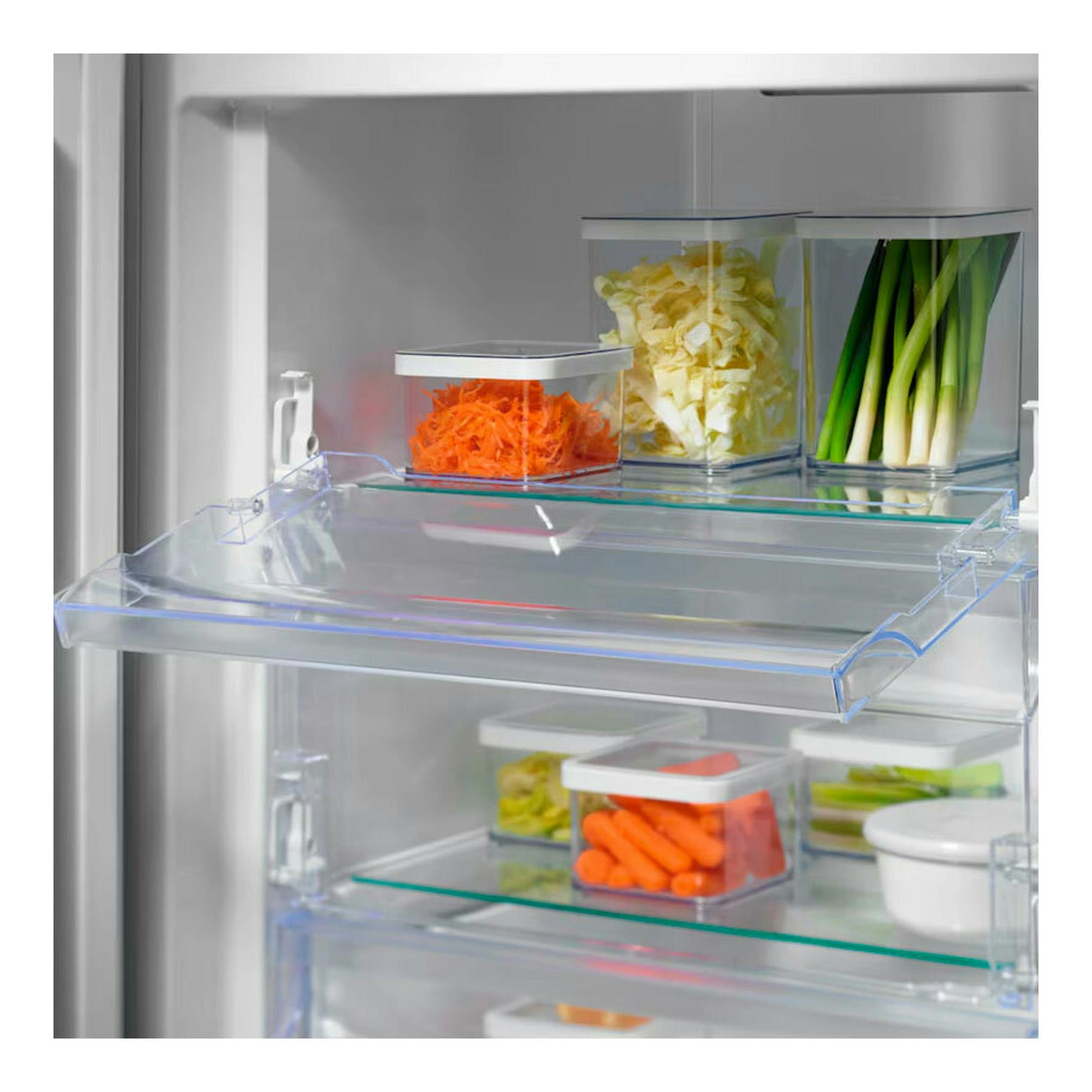 Interior del congelador Electrolux LUT6NE28U inox, vista frontal, con estantes y recipientes con verduras.