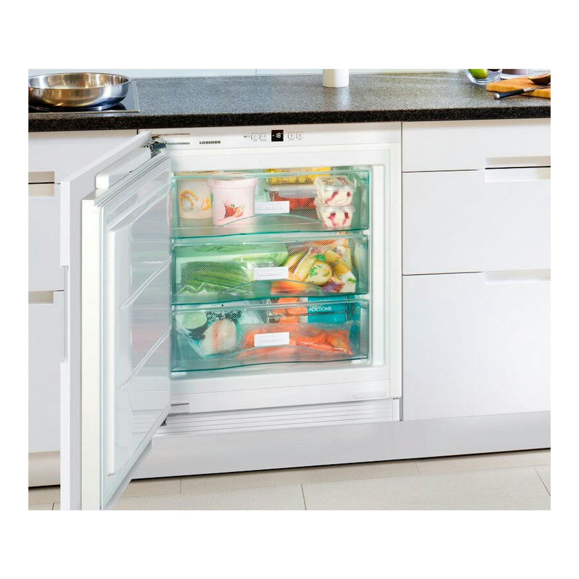 Congelador integrable Liebherr SUIG 1514 blanco, puerta abierta y cajones transparentes en cocina.
