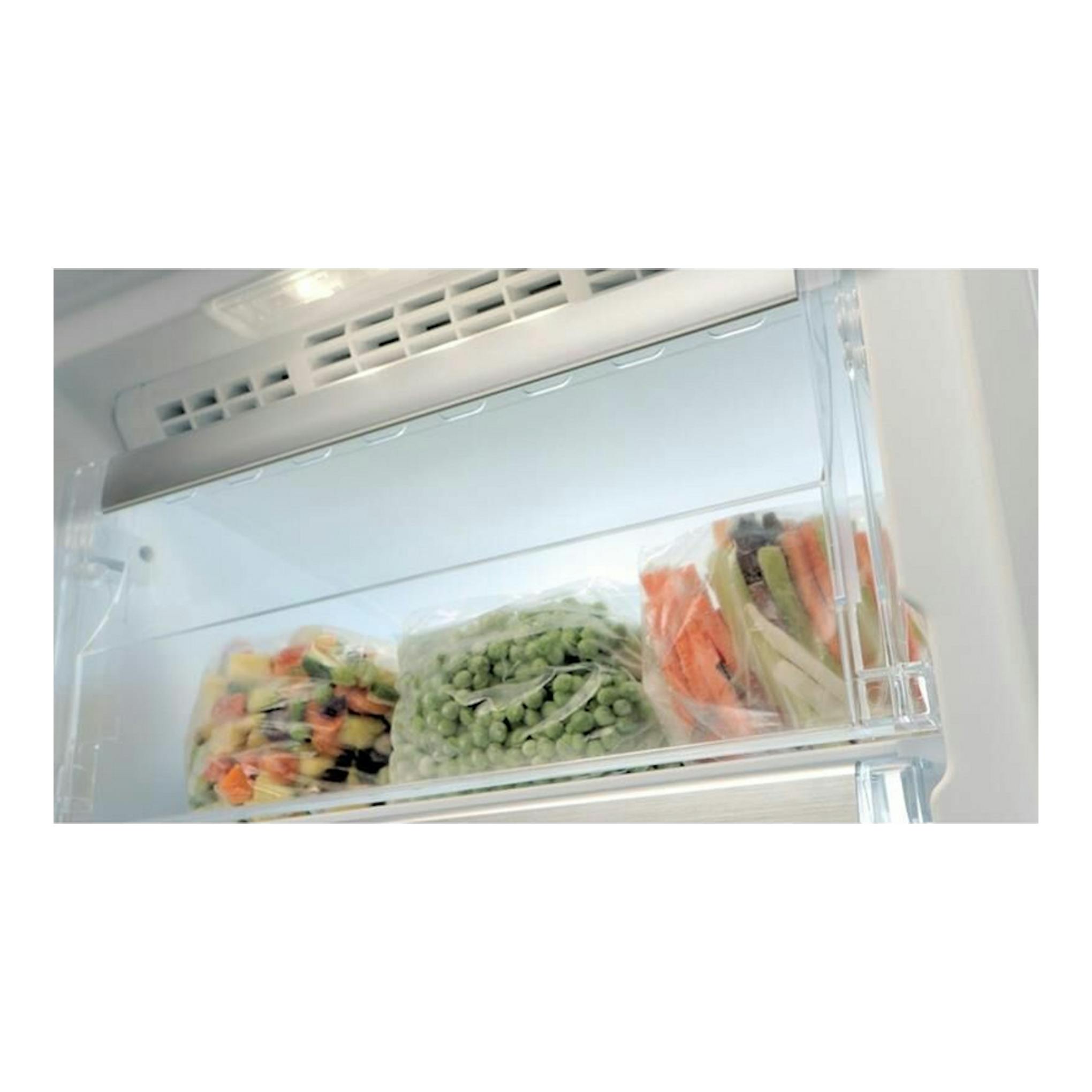 Interior de congelador vertical Whirlpool UW8F2YWBIF2 blanco, con cajón y bolsas de verduras congeladas.
