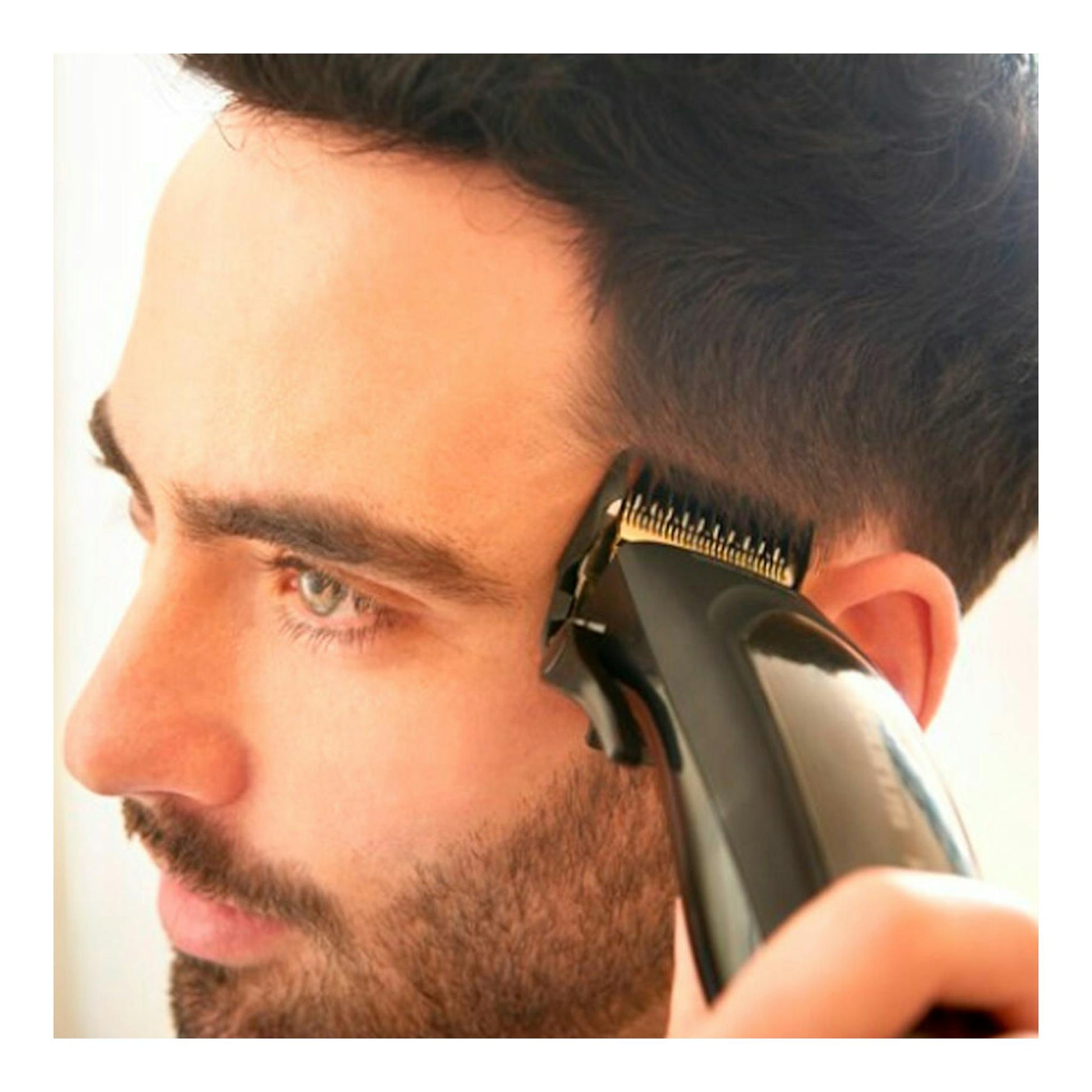 Cortapelos Taurus Mithos Avant Plus negro usado en perfil de un hombre cortando el cabello junto a la oreja.