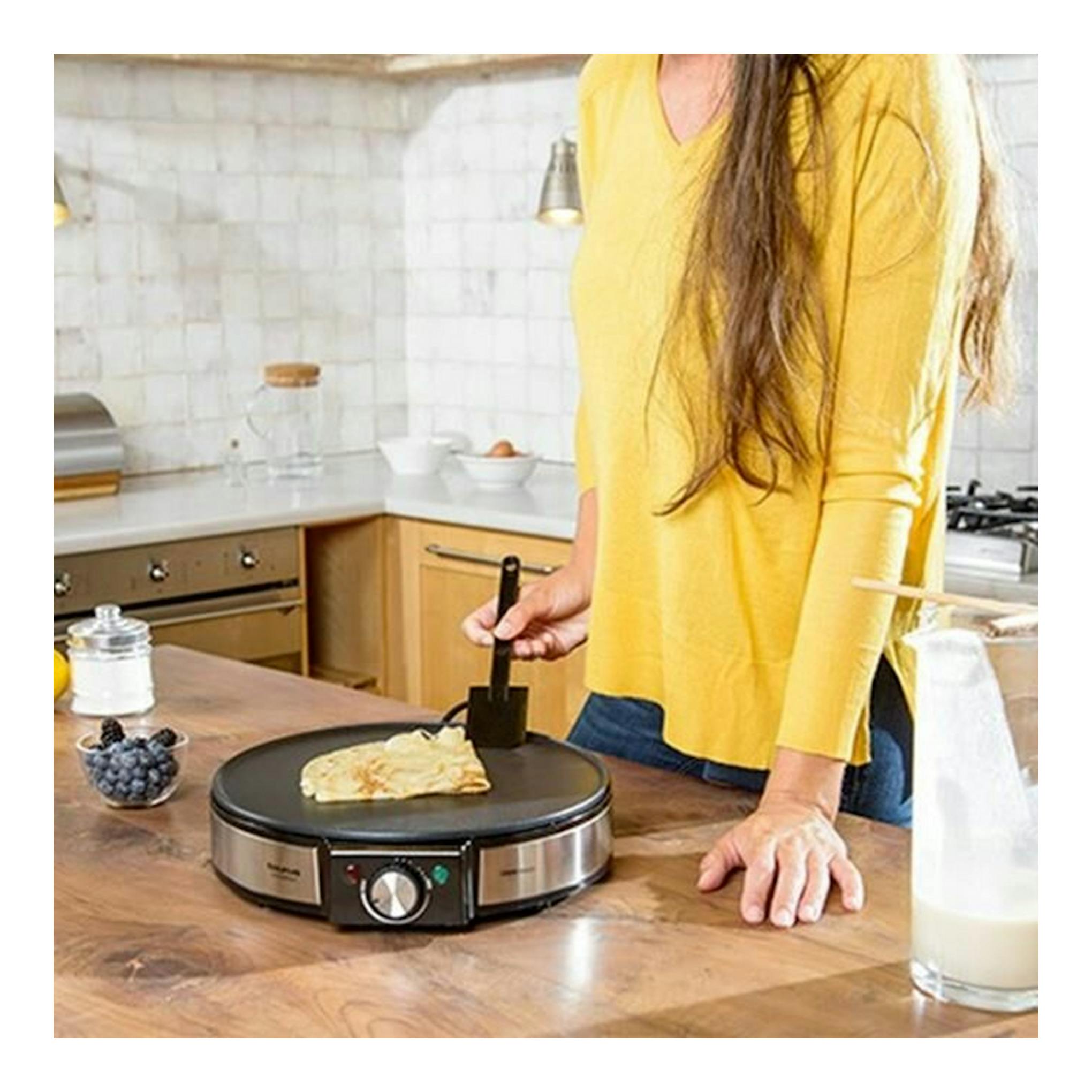 Crepera Taurus S164 negra y acero inoxidable en una cocina, con una crepa cocinándose sobre la placa.
