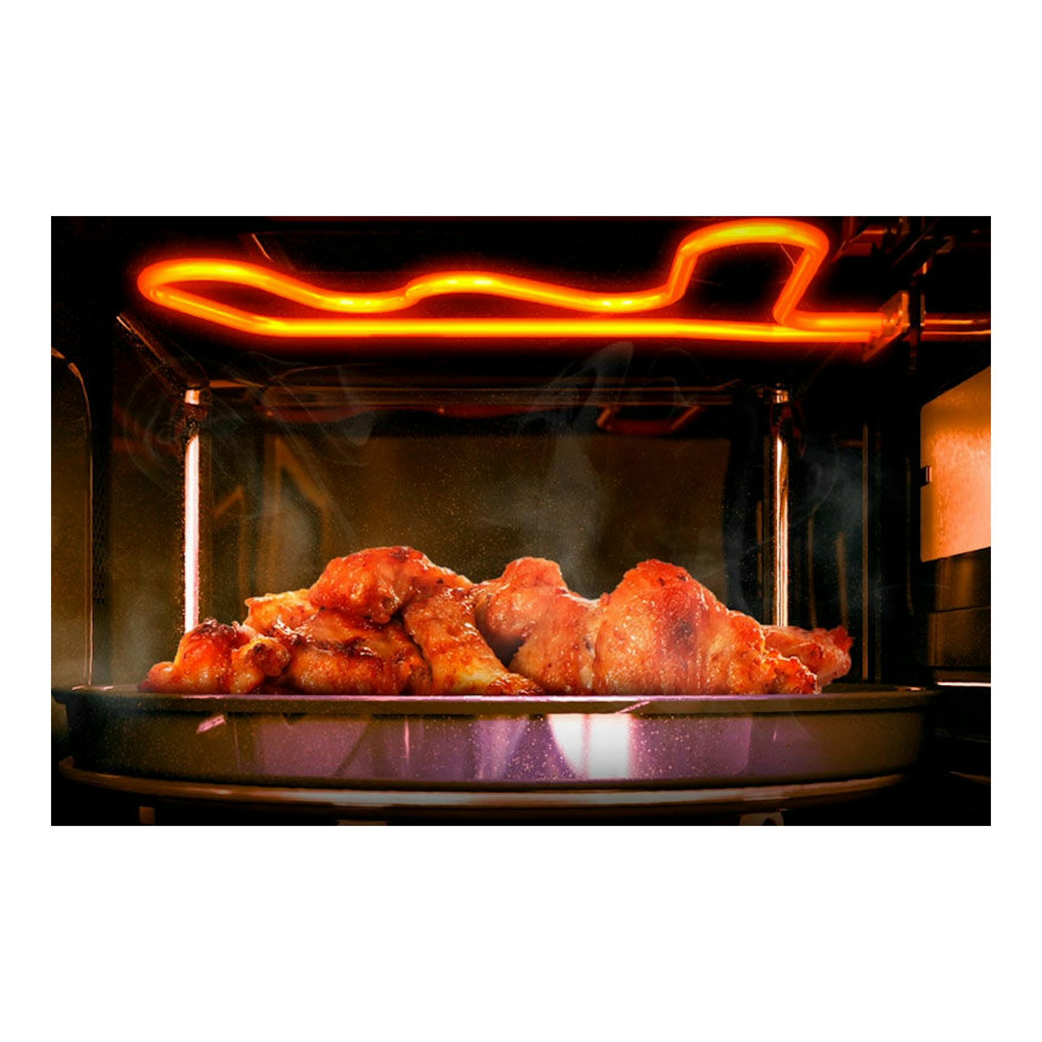 Microondas Samsung MG23A7013CT/EC inox, vista interior con pollo asado bajo una resistencia naranja.