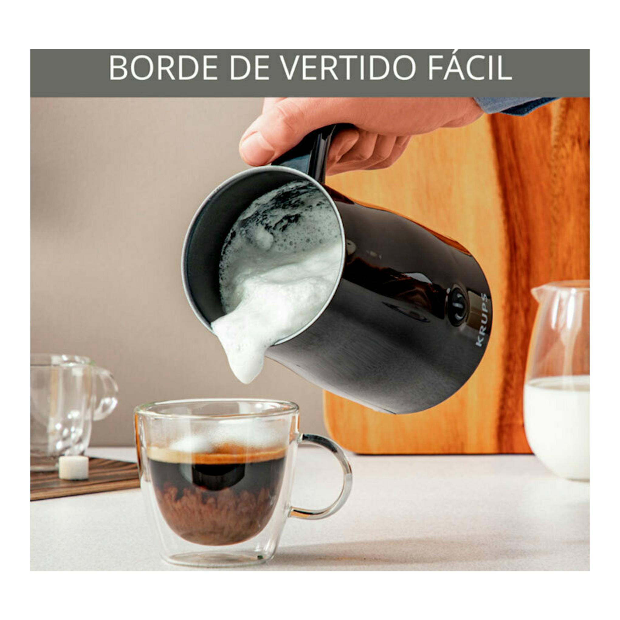 Espumador de leche Krups XL100810 negro vertiendo espuma en una taza de café, vista lateral.