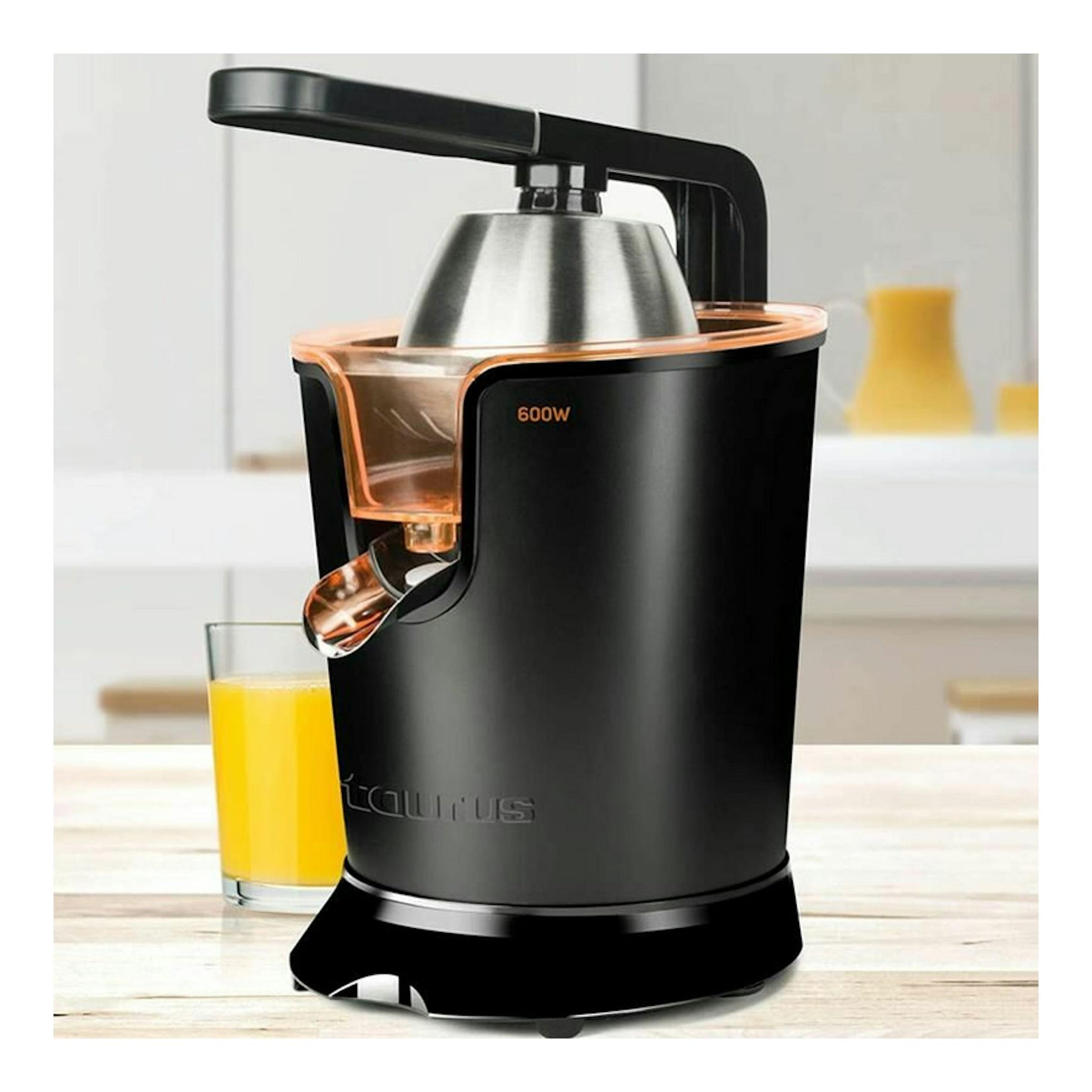 Exprimidor Taurus Easy Press 600 negro, vista frontal, con detalles cobre y vaso de zumo al lado.