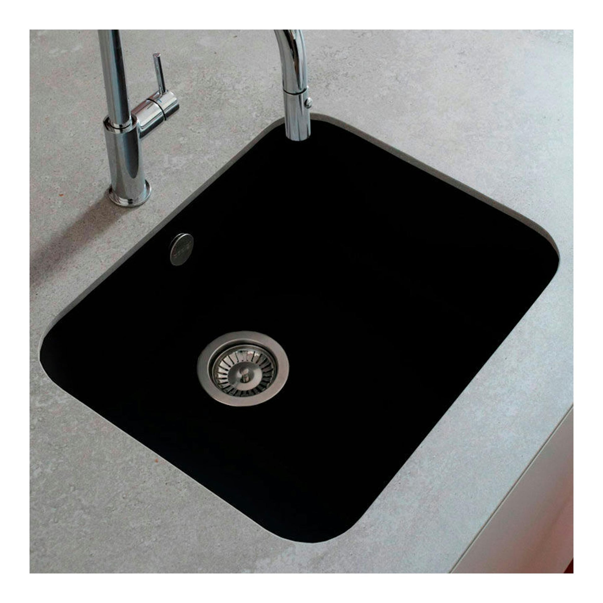 Fregadero Poalgi Essenzial 50 Basalto, vista cenital, negro empotrado en encimera gris con grifo cromado.