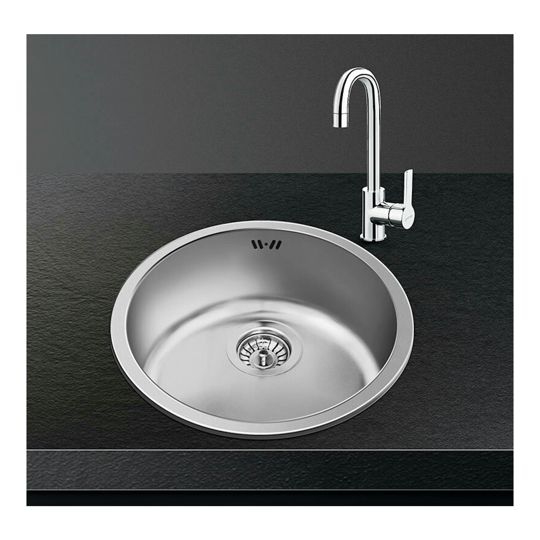 Fregadero Smeg VFU43SFR de acero inoxidable, vista superior, con grifo cromado sobre encimera negra.