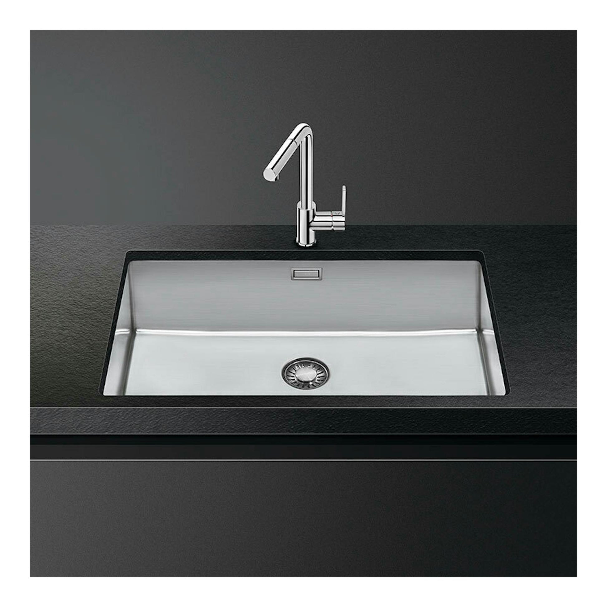Fregadero Smeg VR12S70 de acero inoxidable, vista frontal con grifo cromado en encimera oscura.