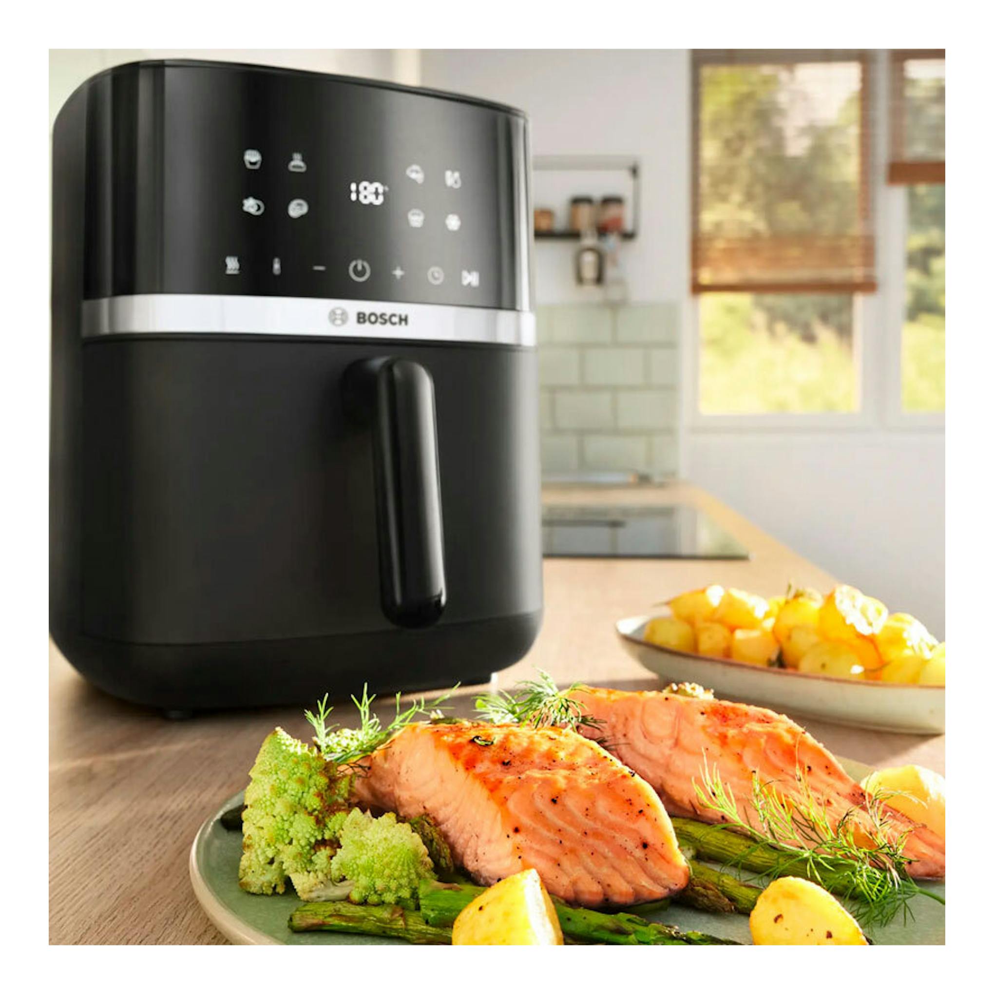 Freidora de aire Bosch MAF462B0 negra, vista frontal, con panel táctil, sobre encimera de cocina.
