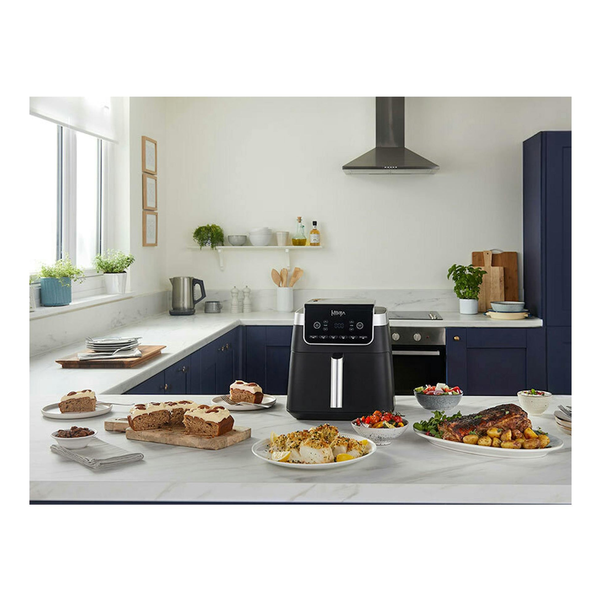 Freidora de aire Ninja AF180EU negra, vista frontal sobre encimera de cocina, con platos de comida alrededor.