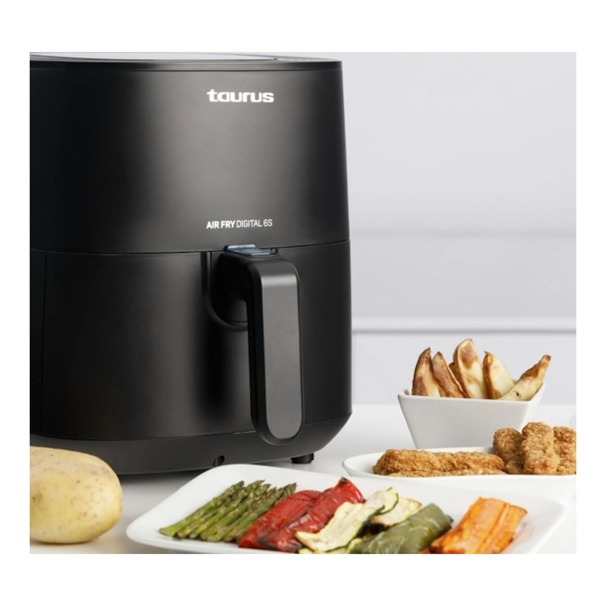 Freidora de aire Taurus Air Fry Digital 6S negra, vista frontal, con cesta y alimentos alrededor.