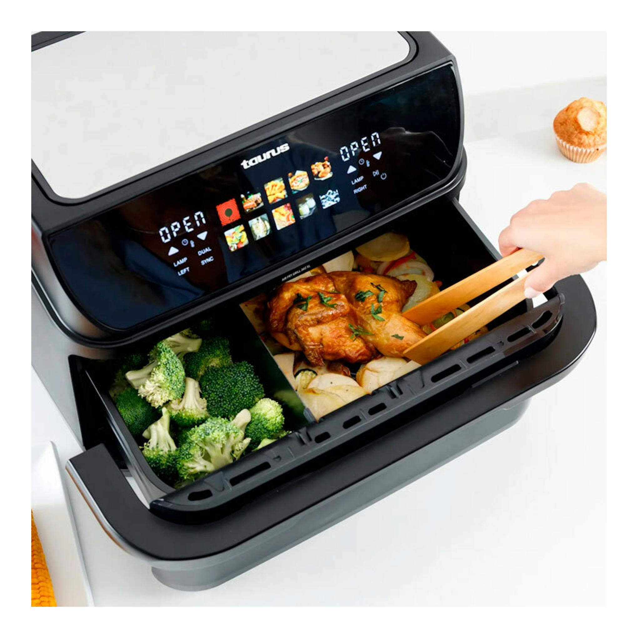 Freidora de aire Taurus Grill 360 negra, vista frontal abierta, con pollo y brócoli en la cesta.