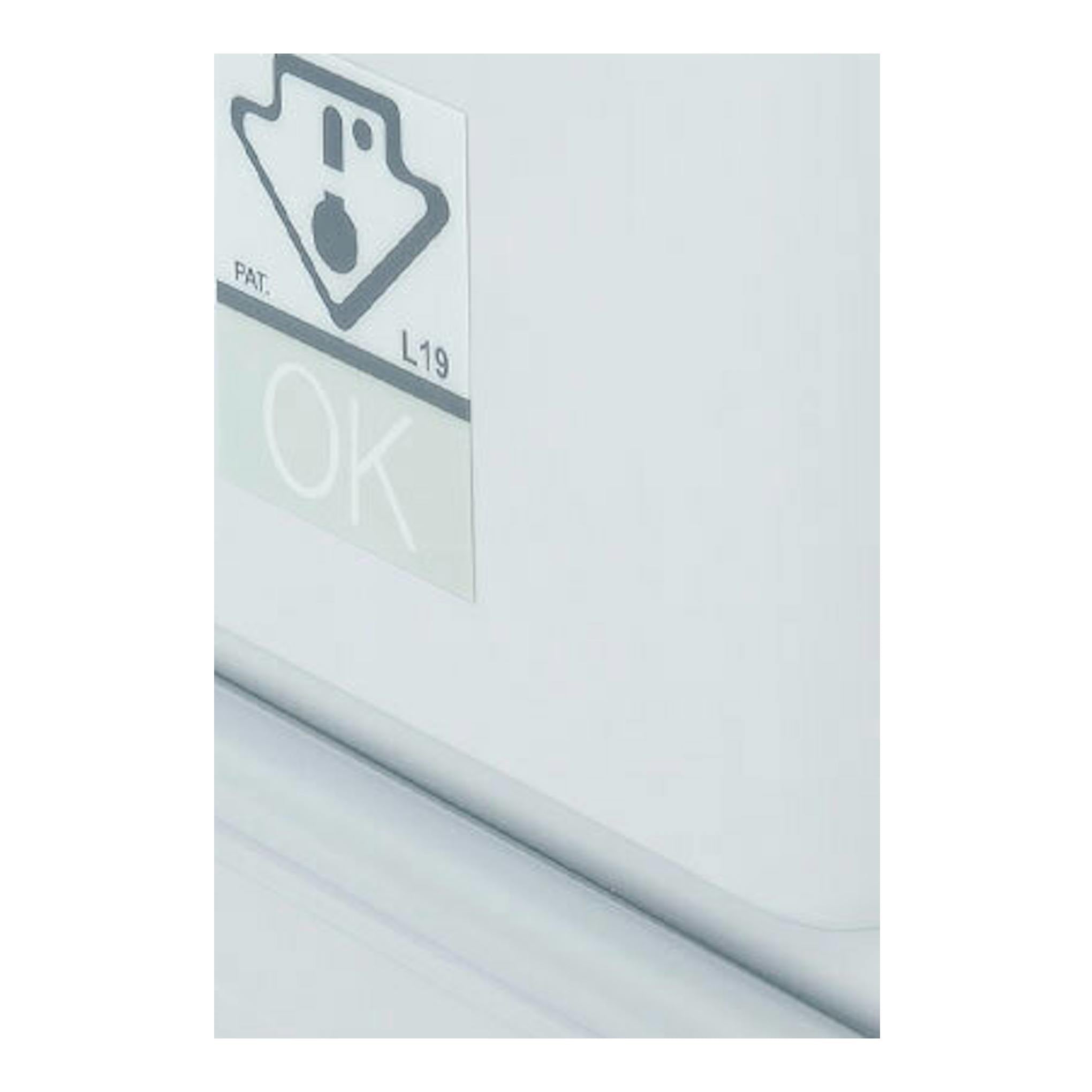 Interior de frigorífico blanco, con cajón plástico transparente y pegatina “OK” en la pared interior.