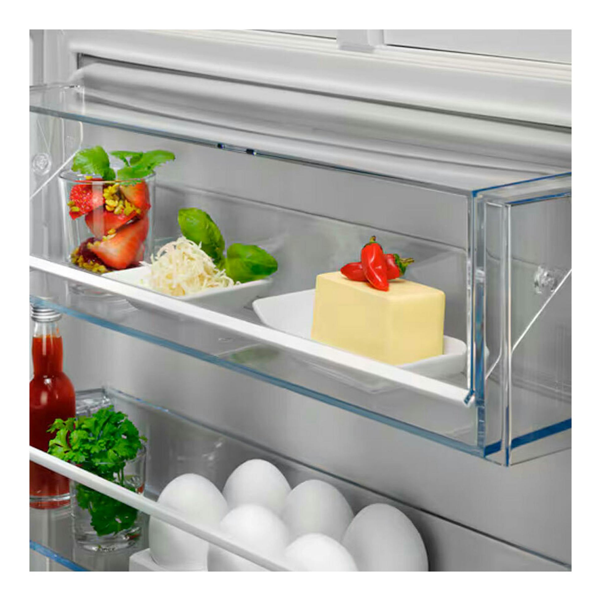 Frigorífico integrable AEG TK6DS181ES, vista interior de la puerta con estantes, huevos, botellas y alimentos.