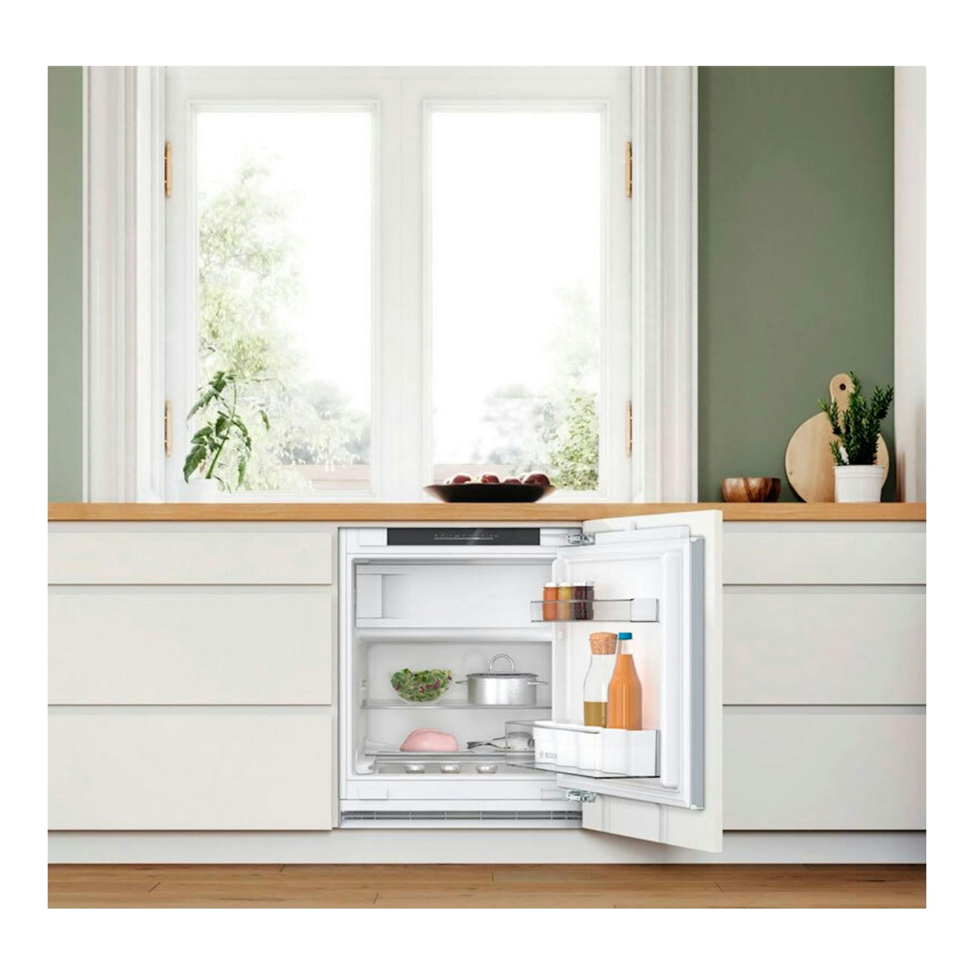 Frigorífico integrable Bosch KUL22VFD0, puerta abierta, vista frontal en cocina blanca.