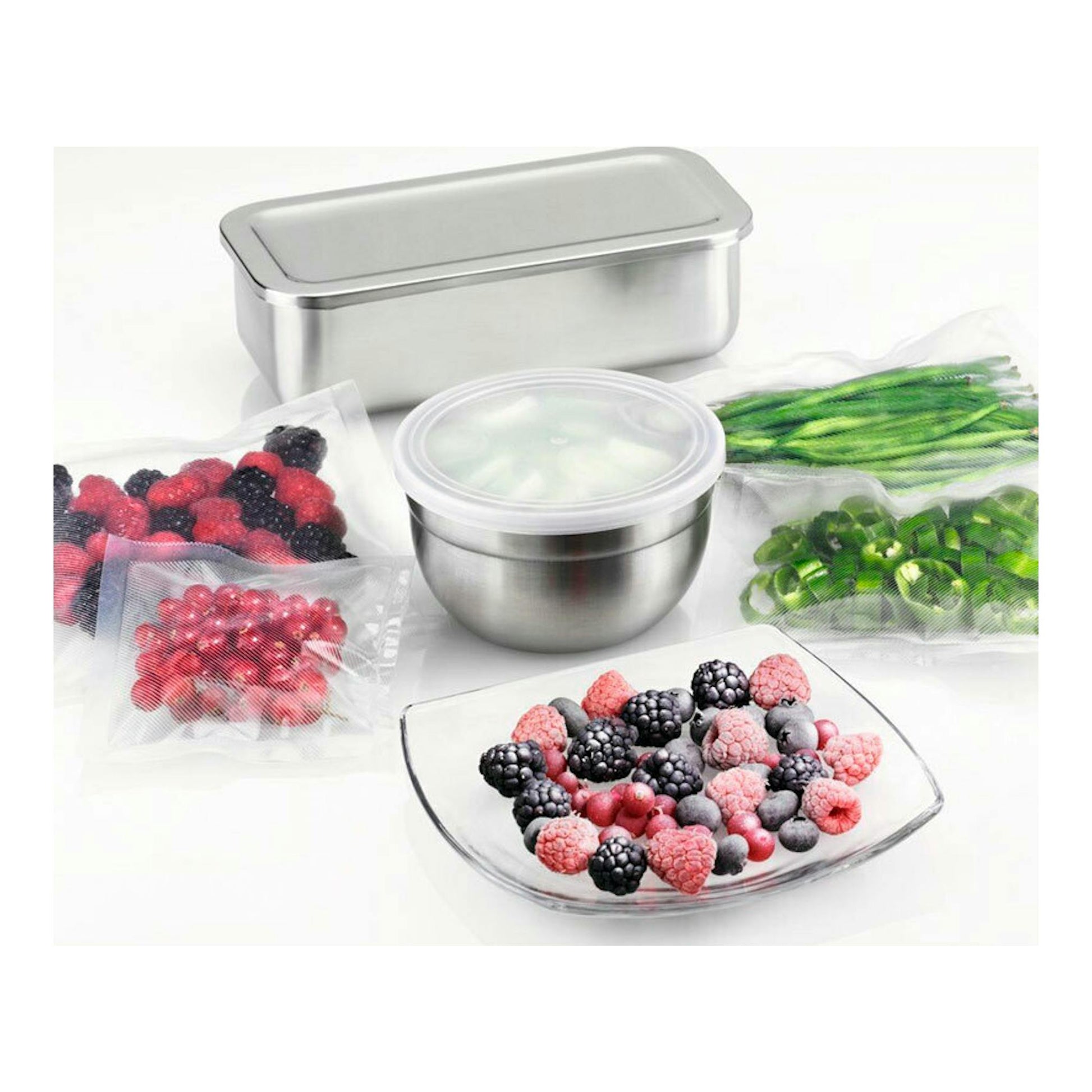 Recipientes de acero inoxidable con tapas, bolsas de vacío y frutas y verduras congeladas sobre fondo blanco.
