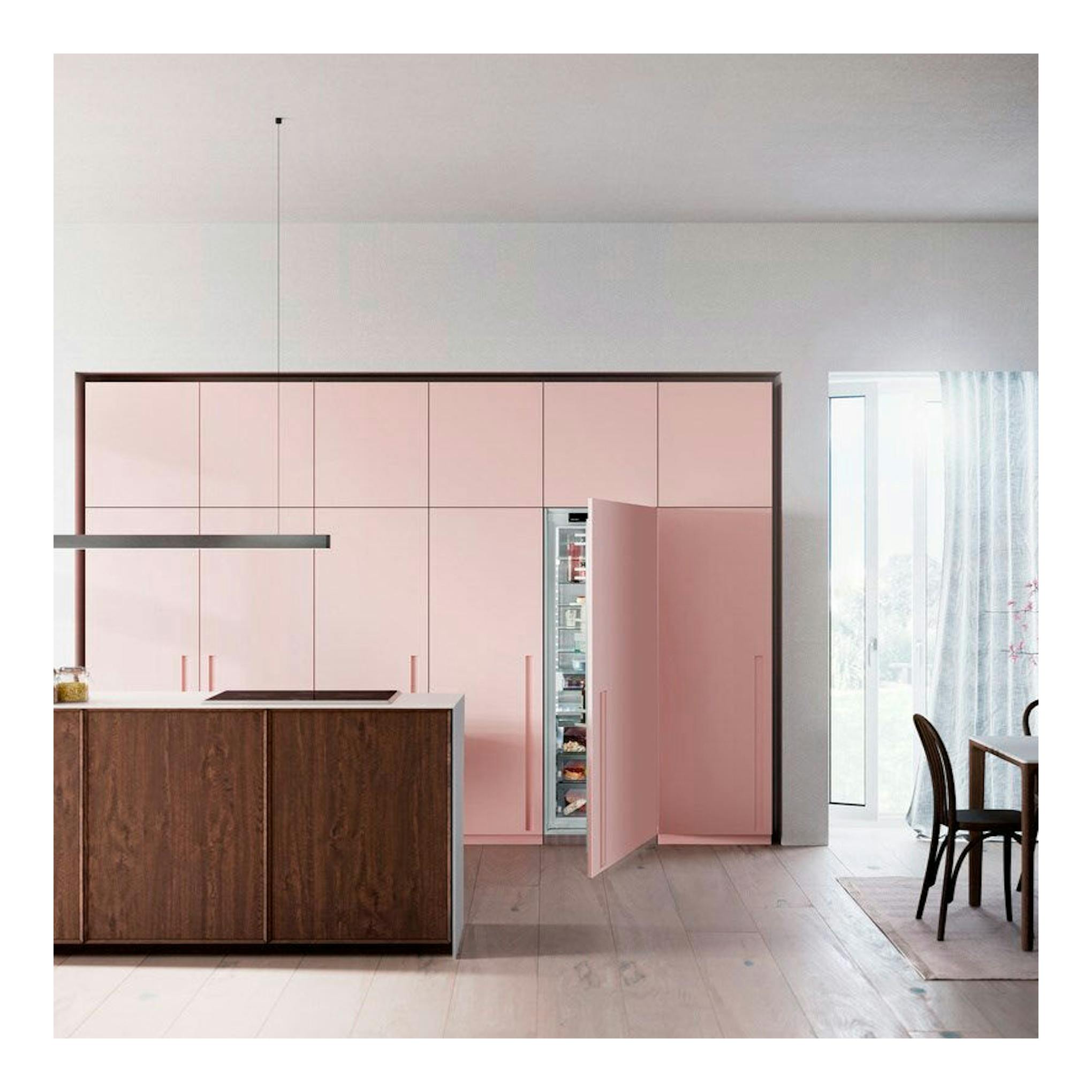 Frigorífico integrable Liebherr IRBci 5180 en cocina rosa, con la puerta abierta y el interior visible.