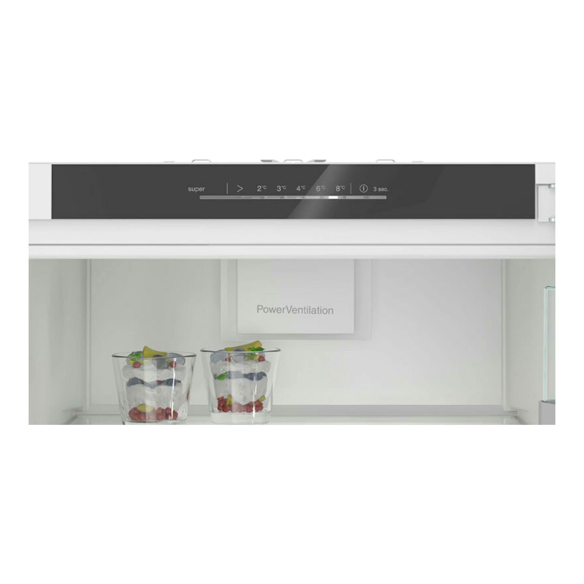 Frigorífico integrable Siemens KI81RADD0, vista frontal del interior blanco con panel superior y dos vasos en la balda.