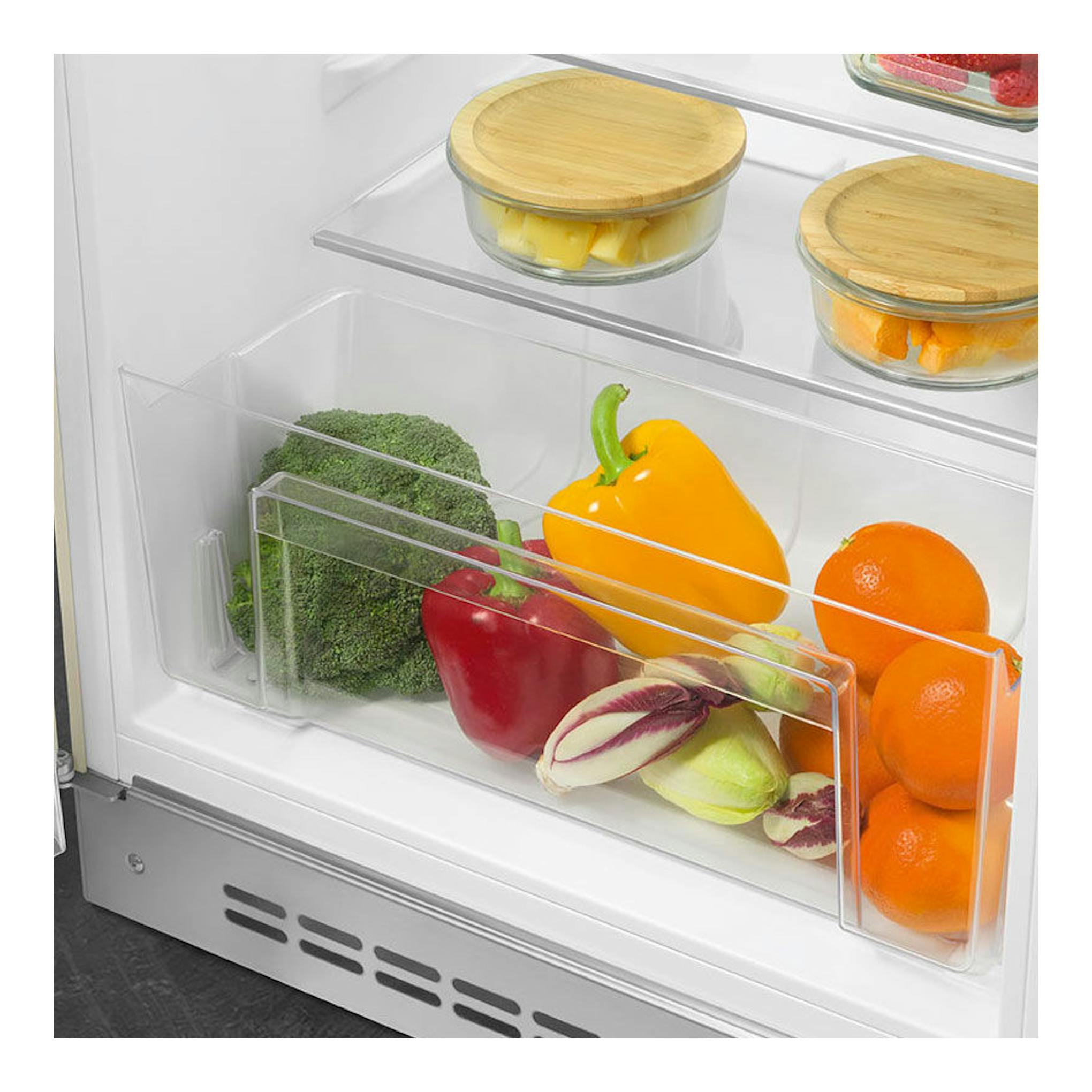 Vista interior de frigorífico Smeg FAB10LCR5 crema, con cajón transparente y verduras y frutas.