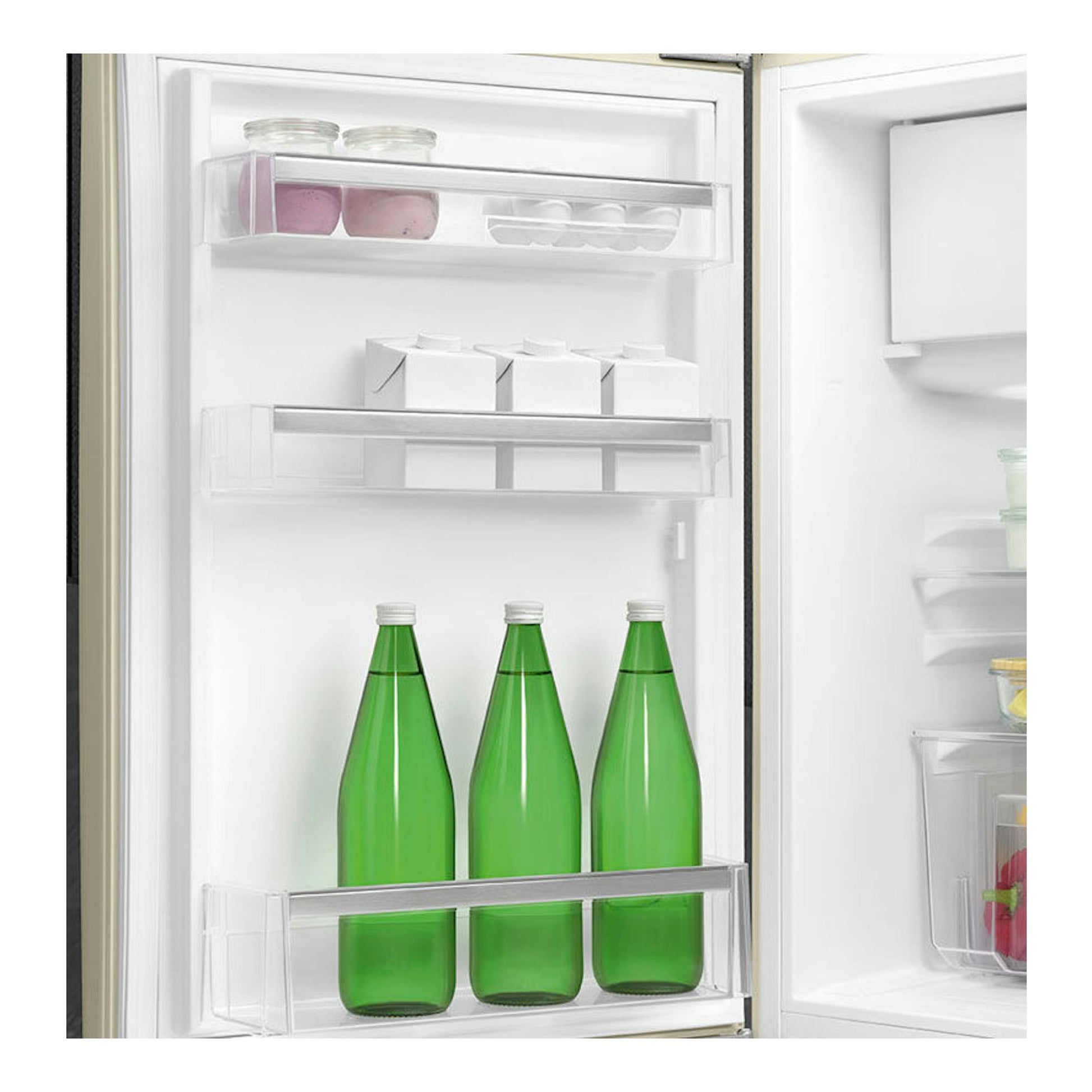 Interior de frigorífico Smeg FAB10LCR5 crema, vista frontal, con botellas verdes y estantes transparentes.